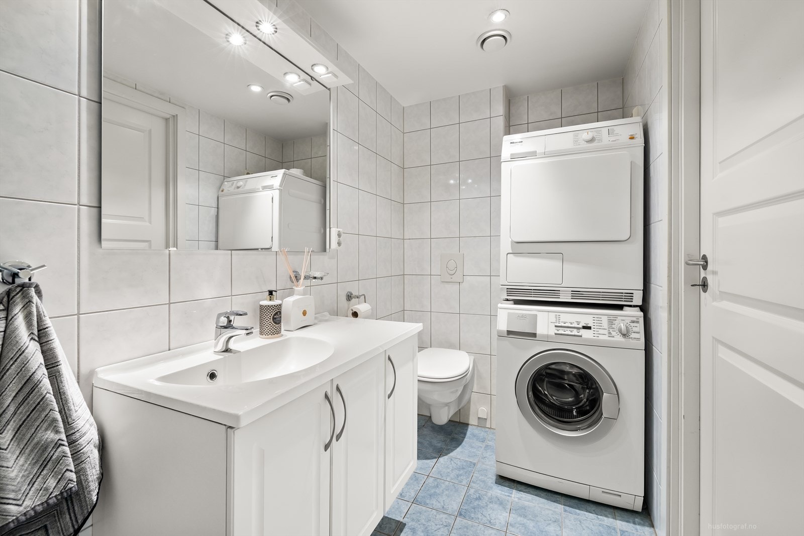 Det er vegghengt toalett og opplegg for vaskemaskin/tørketrommel. Galleribilde