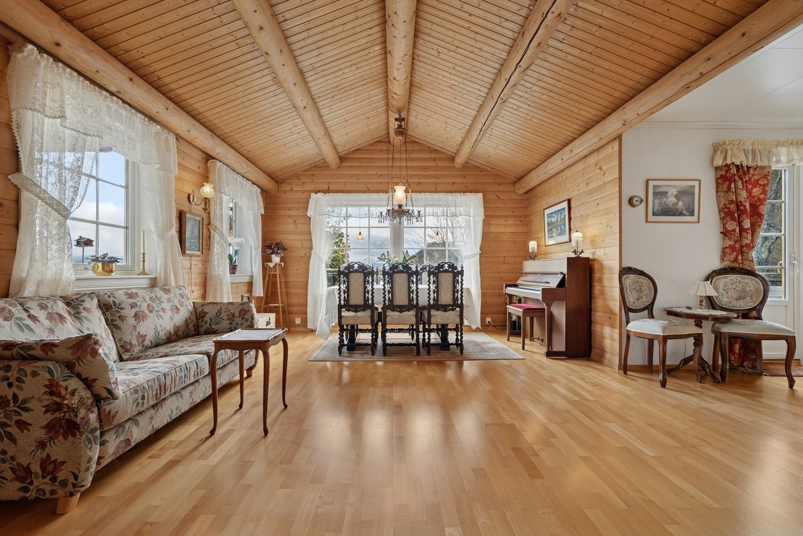 En særdeles romslig stue med plass for både stor spisegruppe og sofaløsninger. Galleribilde