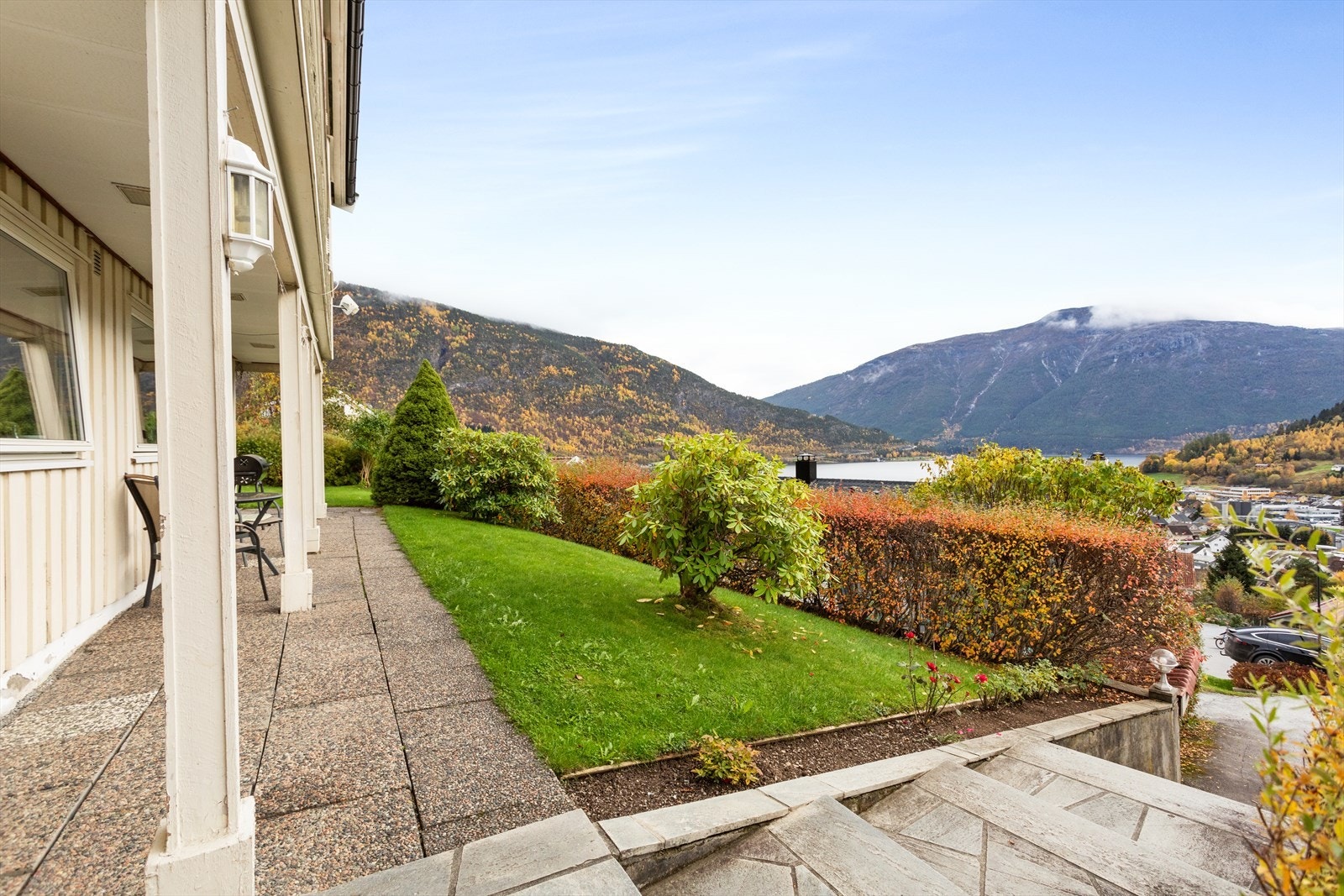 Fin opparbeid hage med trapper, steinheller og blomsterbed. Galleribilde