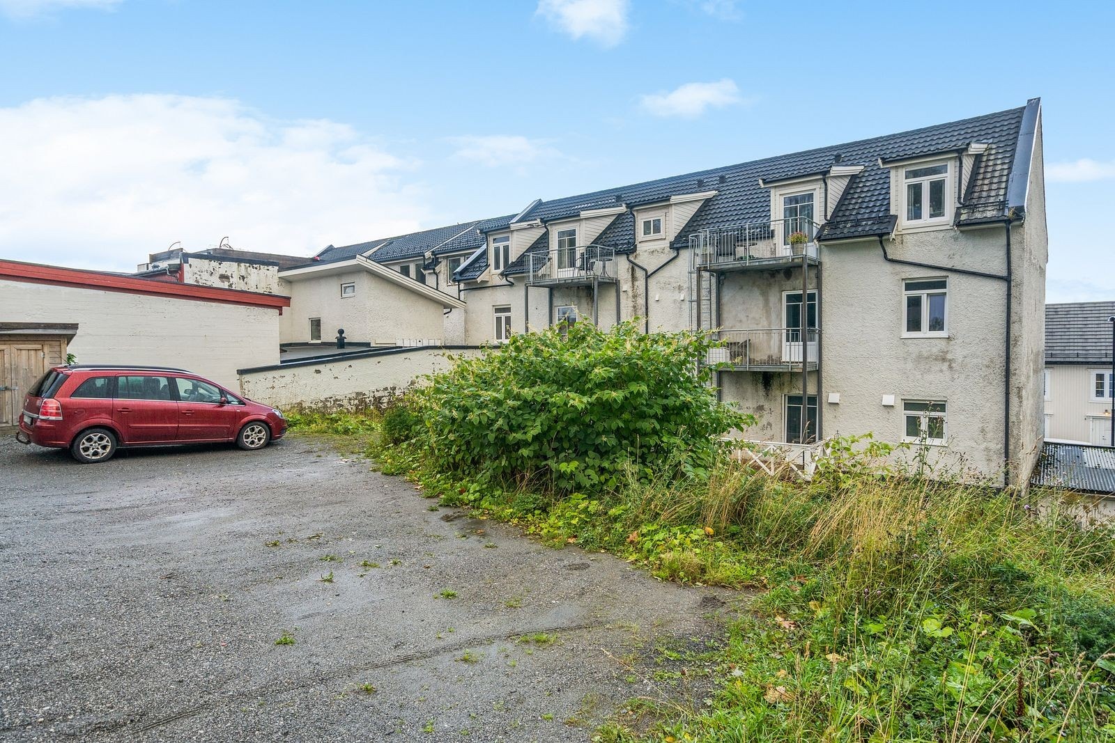 Parkeringsareal ved Håreks gate. Sameiet leier også noen parkeringsplasser i bakgården til tkg 50 som er nærmeste nabo. Nede på bakkeplan er uteboden som tilhører seksjonen. Galleribilde