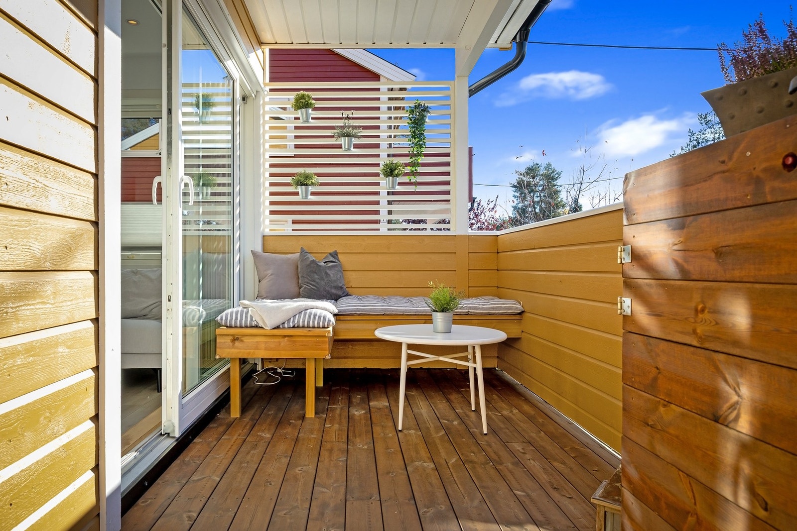 På verandaen er det plassbygget sittebenk og innbygget gassgrill Galleribilde