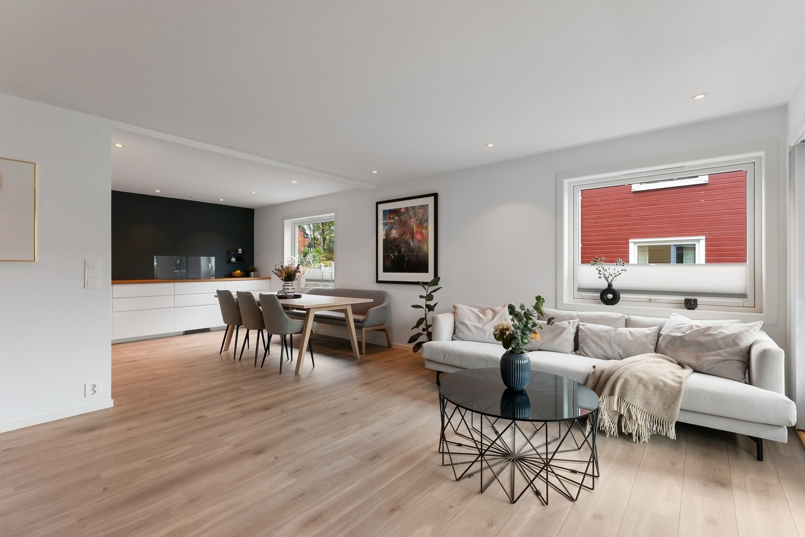 Stor stue og kjøkken i åpen løsning med vindusflater på to sider Galleribilde