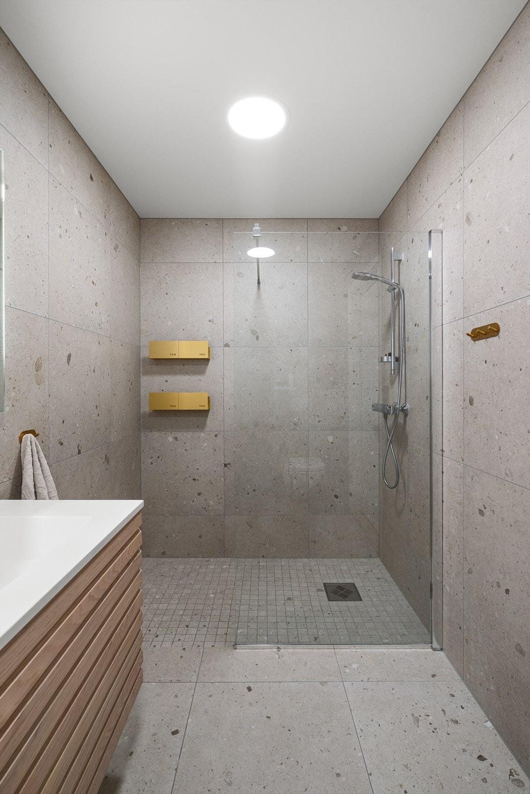 Delikat baderom med 60*60 fliser på gulv og vegger. Det er mosaikkfliser på gulv i dusjsonen. Galleribilde