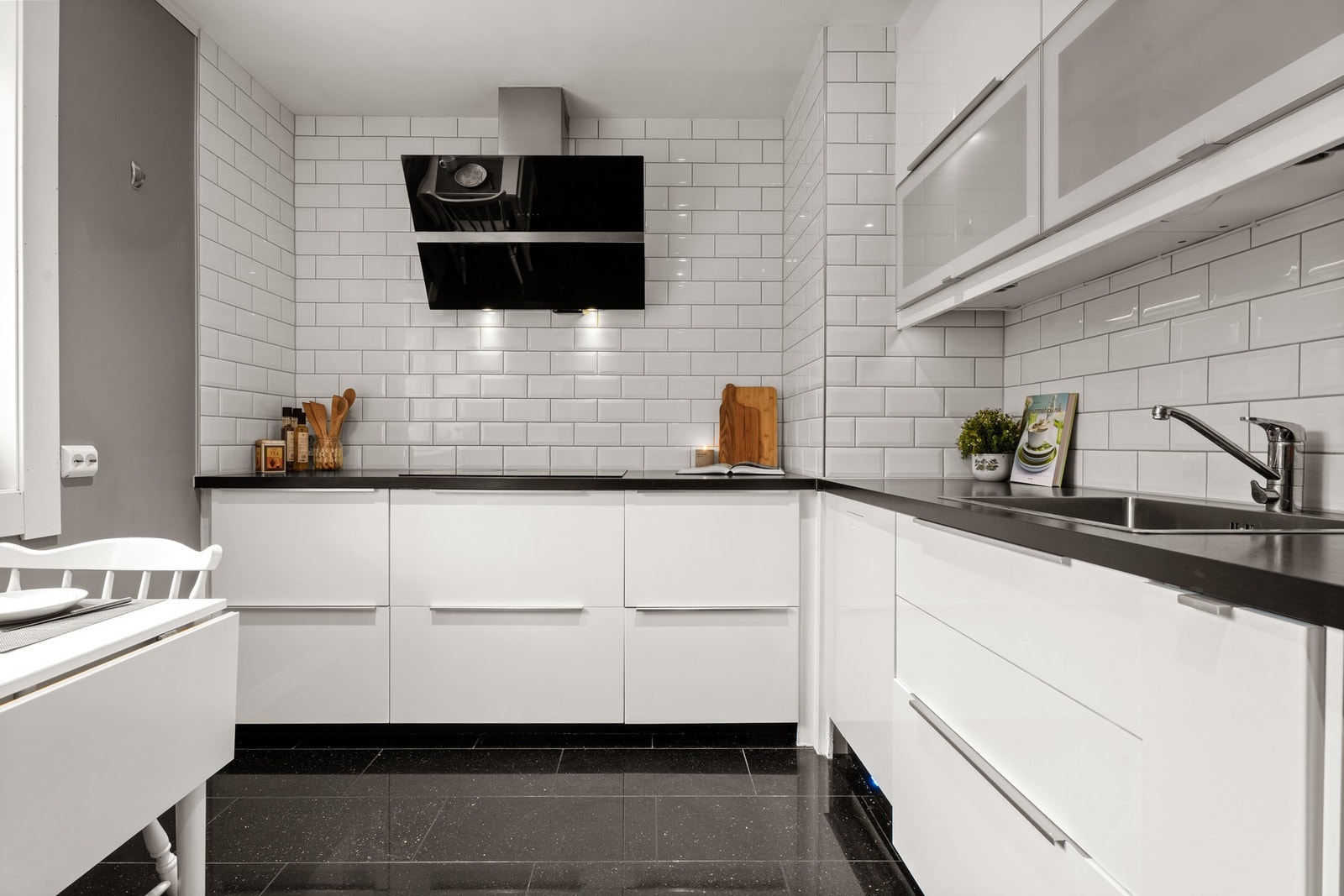 Kjøkkenet har hvit høyglans kjøkkeninnredning fra 2015, med laminert benkeplate og nedfelt oppvaskkum. Ventilatorhette i stål/glass med kullfilter. Galleribilde