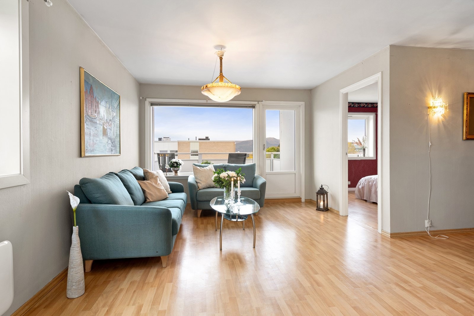 Lys og romslig stue med store vinduer og utgang til balkong. Galleribilde