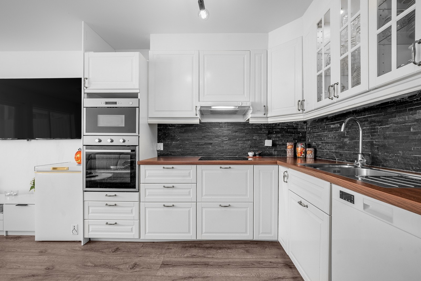 Kjøkken fra 2017 med profilerte fronter, laminatbenkeplate og fliser mellom benk og overskap. Galleribilde