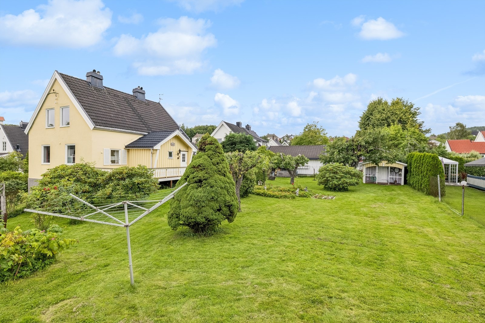 Hagen er inngjerdet, pent opparbeidet med plen samt diverse beplantninger og frukttrær. Galleribilde