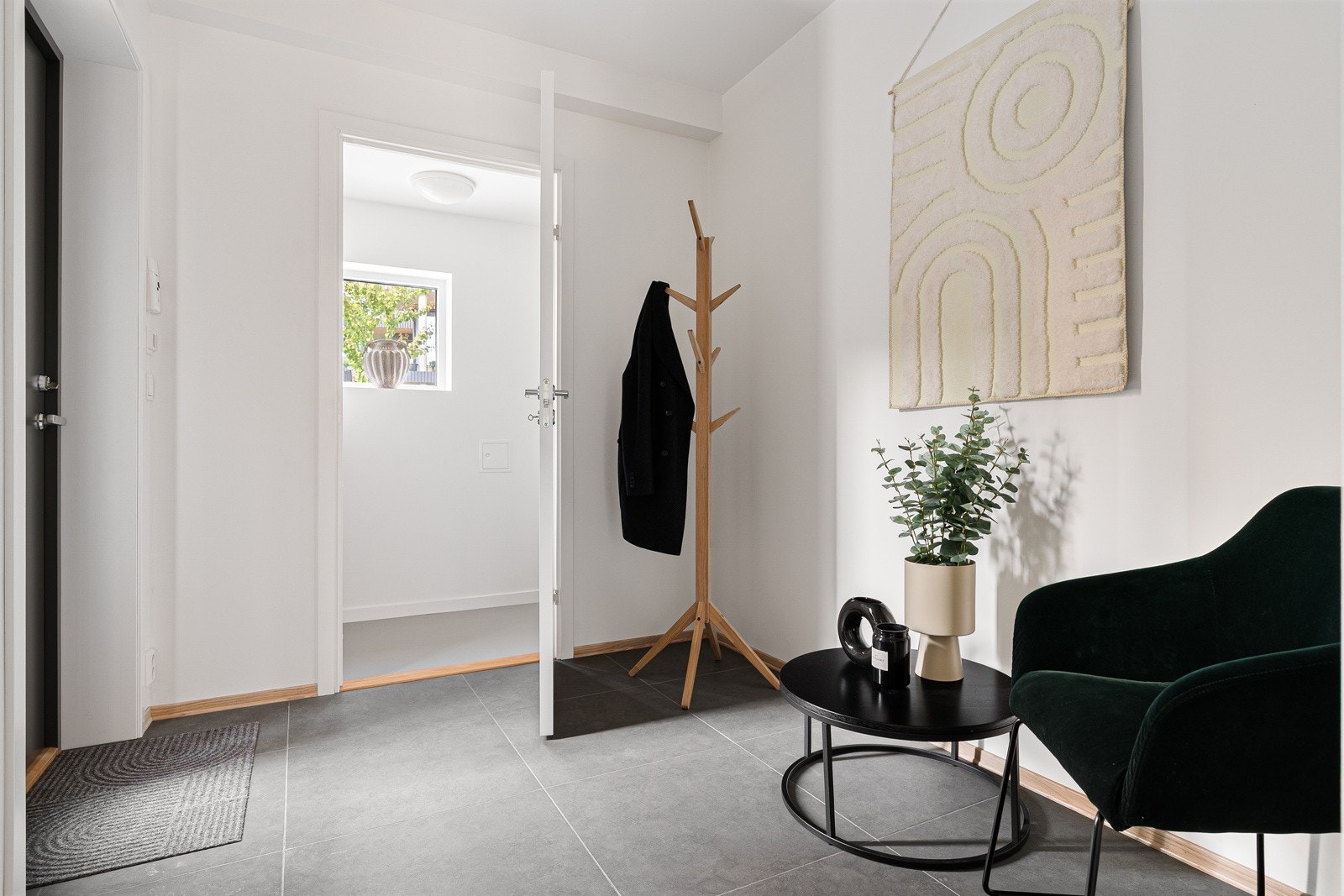 Fra inngangspartiet kommer du inn i en lys og praktisk entré som leder videre til stue og kjøkken. Innenfor entréen er det en bod som du kan se i bildet. Både i entré og i bod er det god plass til å henge fra seg yttertøy samt sette fra seg sko. Galleribilde