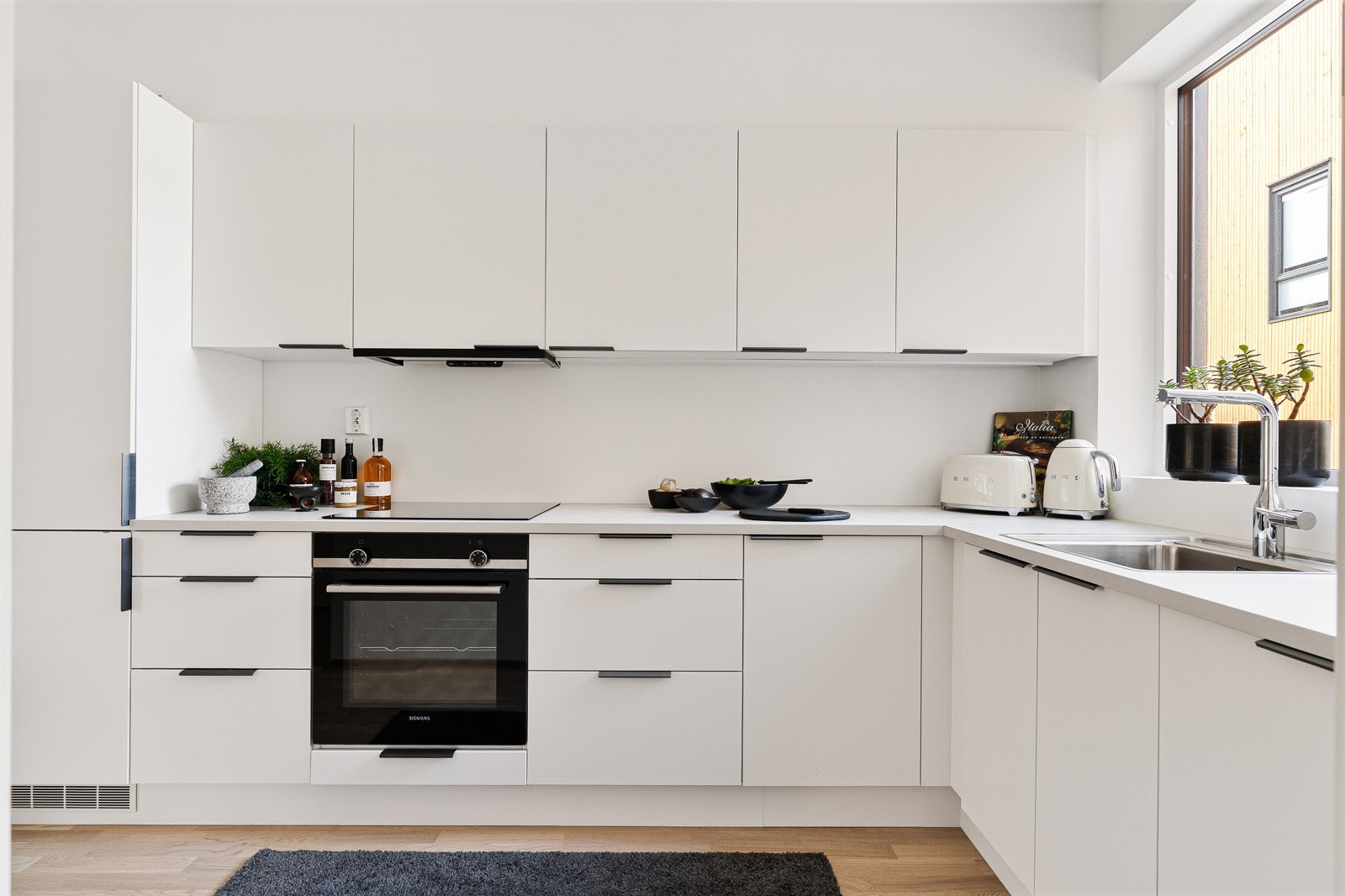 Boligen har et praktisk og tidløst kjøkken med innredning fra Sigdal. Her er rikelig med skap- og benkeplass. Integrerte hvitevarer som induksjonstopp, stekeovn, oppvaskmaskin og kombiskap med kjøl- og frys. Galleribilde