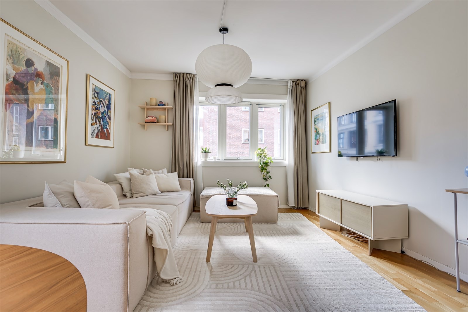 Rommet er badet i naturlig lys fra store vindusflater, og byr på en åpen løsning med god plass til både sofakrok og spisestue - perfekt for både hverdagsliv og sosiale sammenkomster. Galleribilde