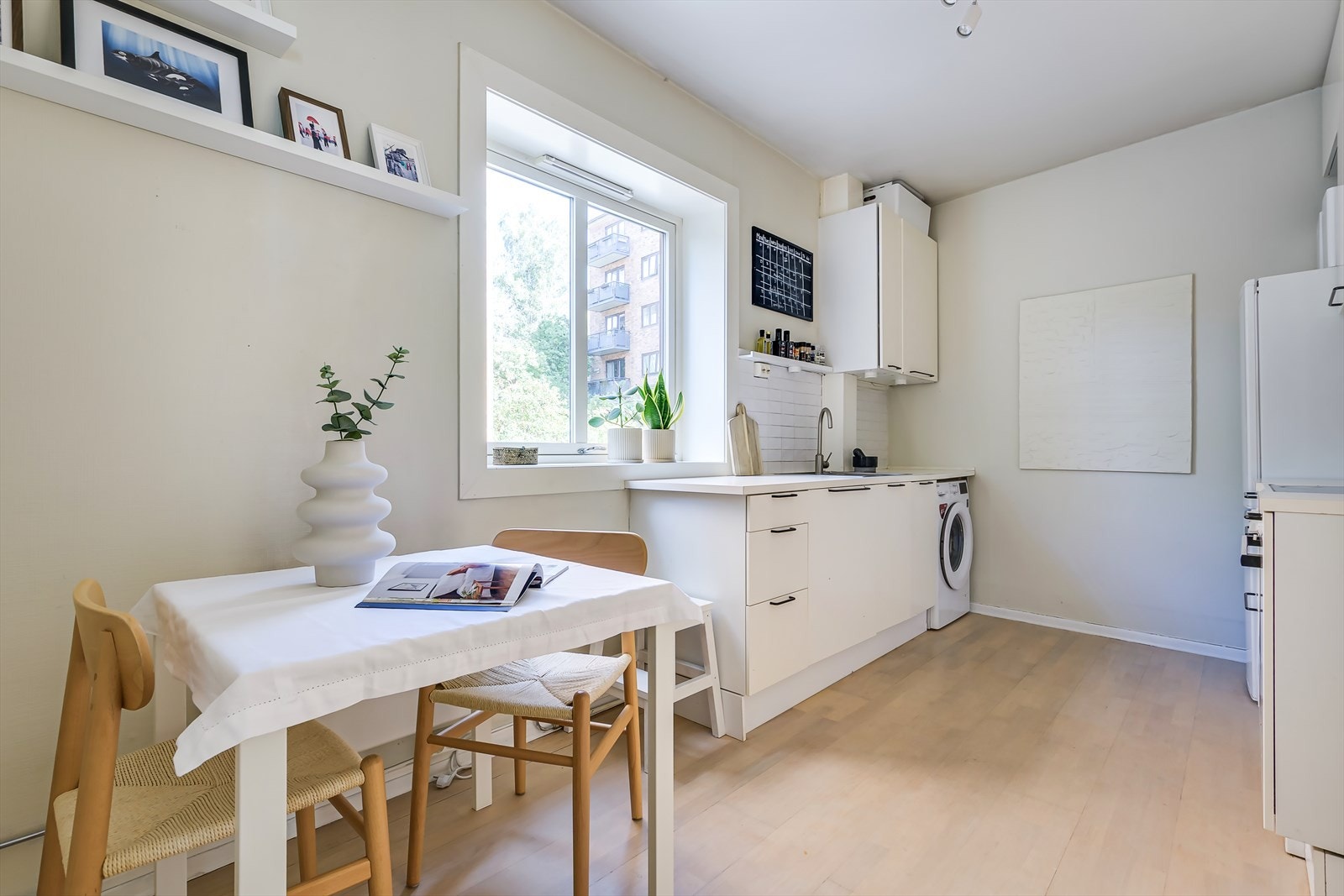 Kjøkkenet er gjennomtenkt innredet med hvite fronter og integrerte løsninger, noe som gir en tidløs og stilren følelse. Galleribilde