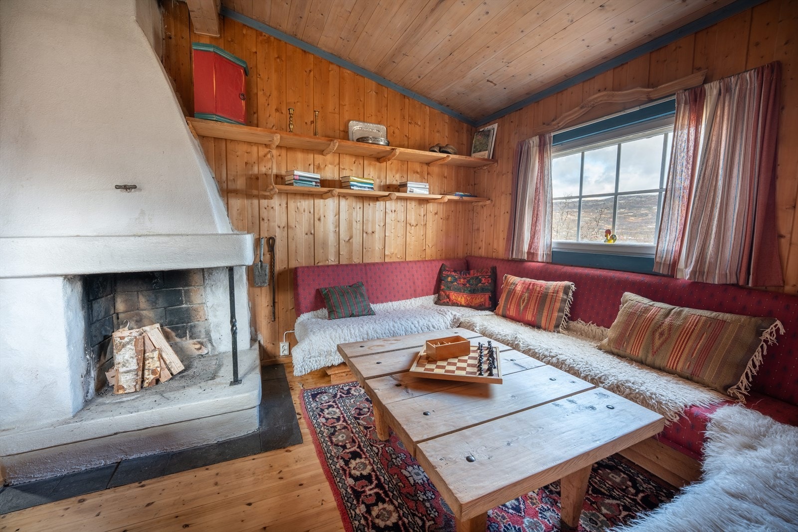 Stue med åpen peis i eldste del av hytte Galleribilde