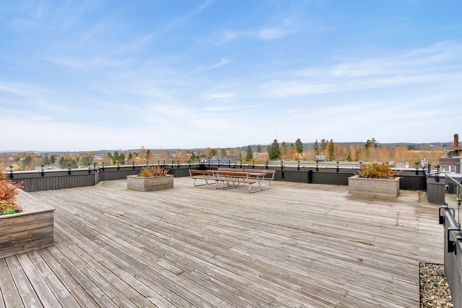 Stor takterrasse med panoramautsikt, sitteplasser og pen beplantning. Galleribilde