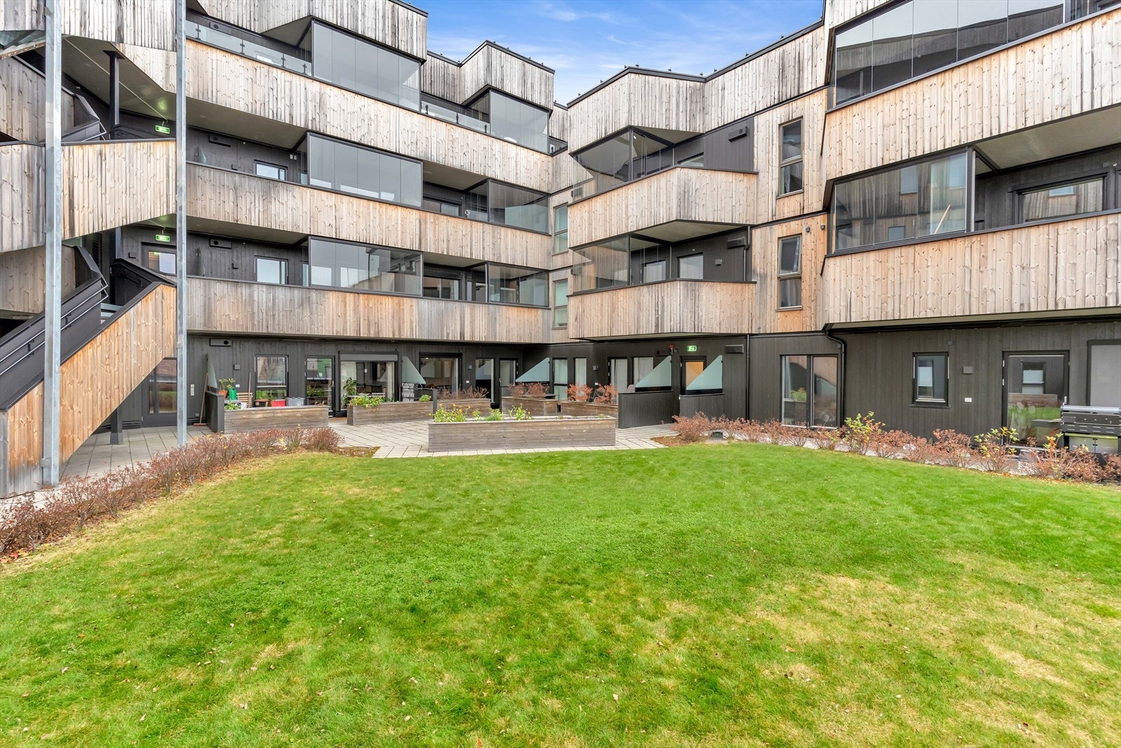 Flotte uteplasser som kan benyttes av alle beboerne. Her er det plenareal, prydbusker og hellelagte gangveier. Galleribilde