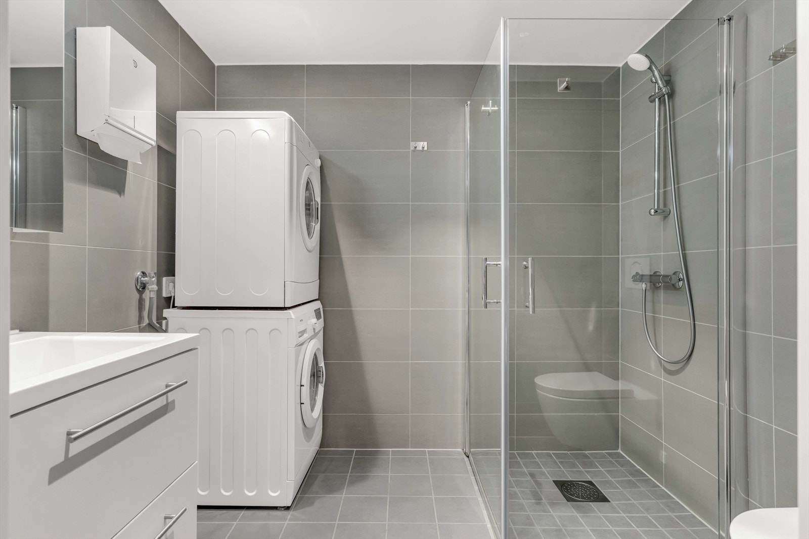 Begge badene har hvit servantinnredning, speilskap, vegghengt toalett og dusjhjørne med dører i glass. Det største er ytterligere utstyrt med opplegg for vaskemaskin/tørketrommel i søyleløsning. Galleribilde