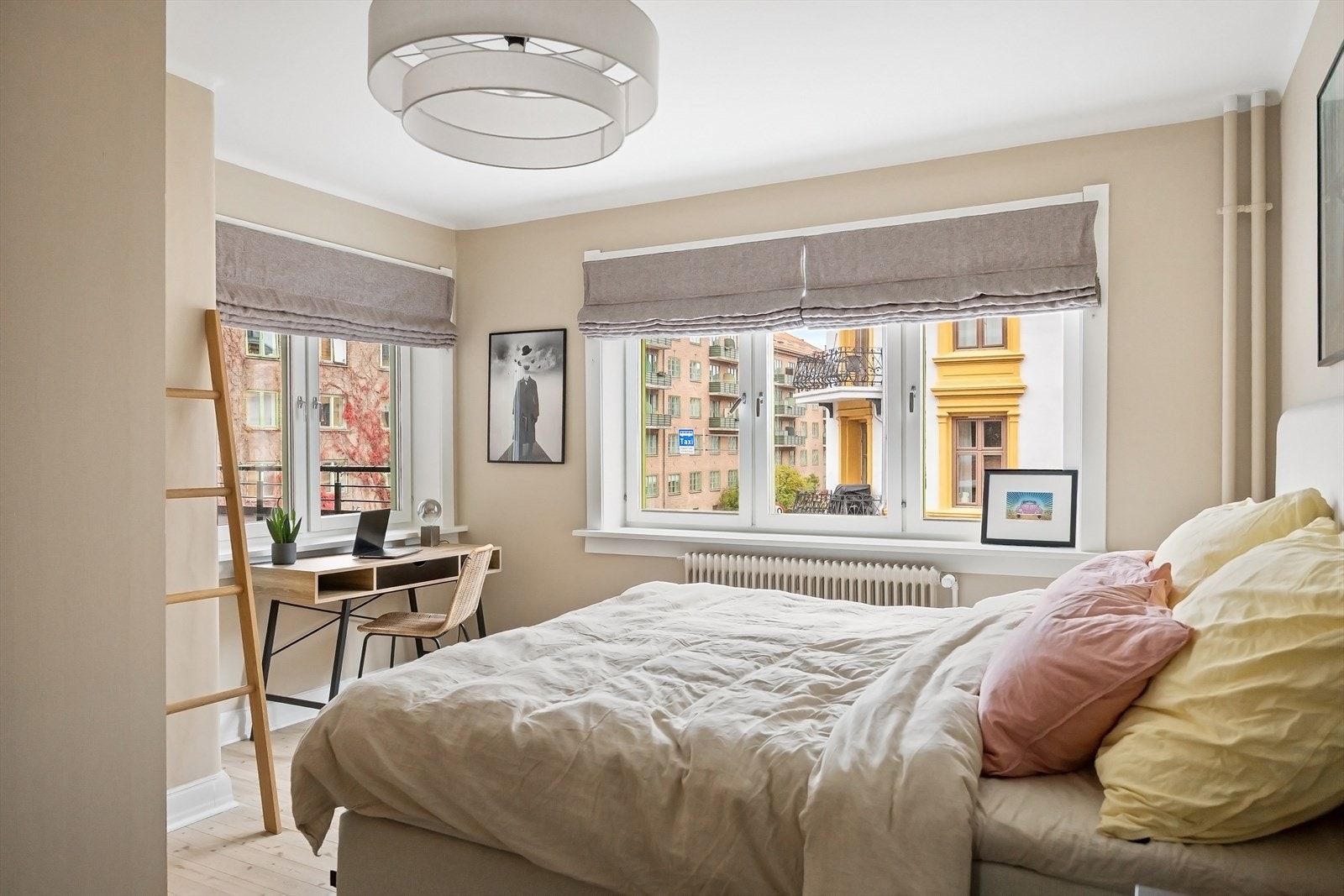 Lyst og romslig soverom med store vinduer og god plass til dobbeltseng med nattbord Galleribilde