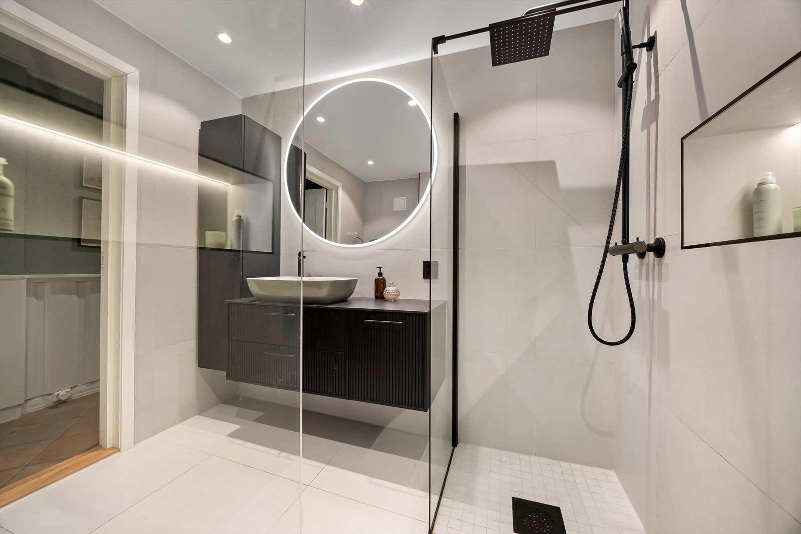 Innredet med vegghengt servantskap fra Svedbergs epos med lekker servant, stort speil med integrert belysning som gir en behagelig atmosfære, samt ekstra vegghengt skap for praktisk oppbevaring Galleribilde