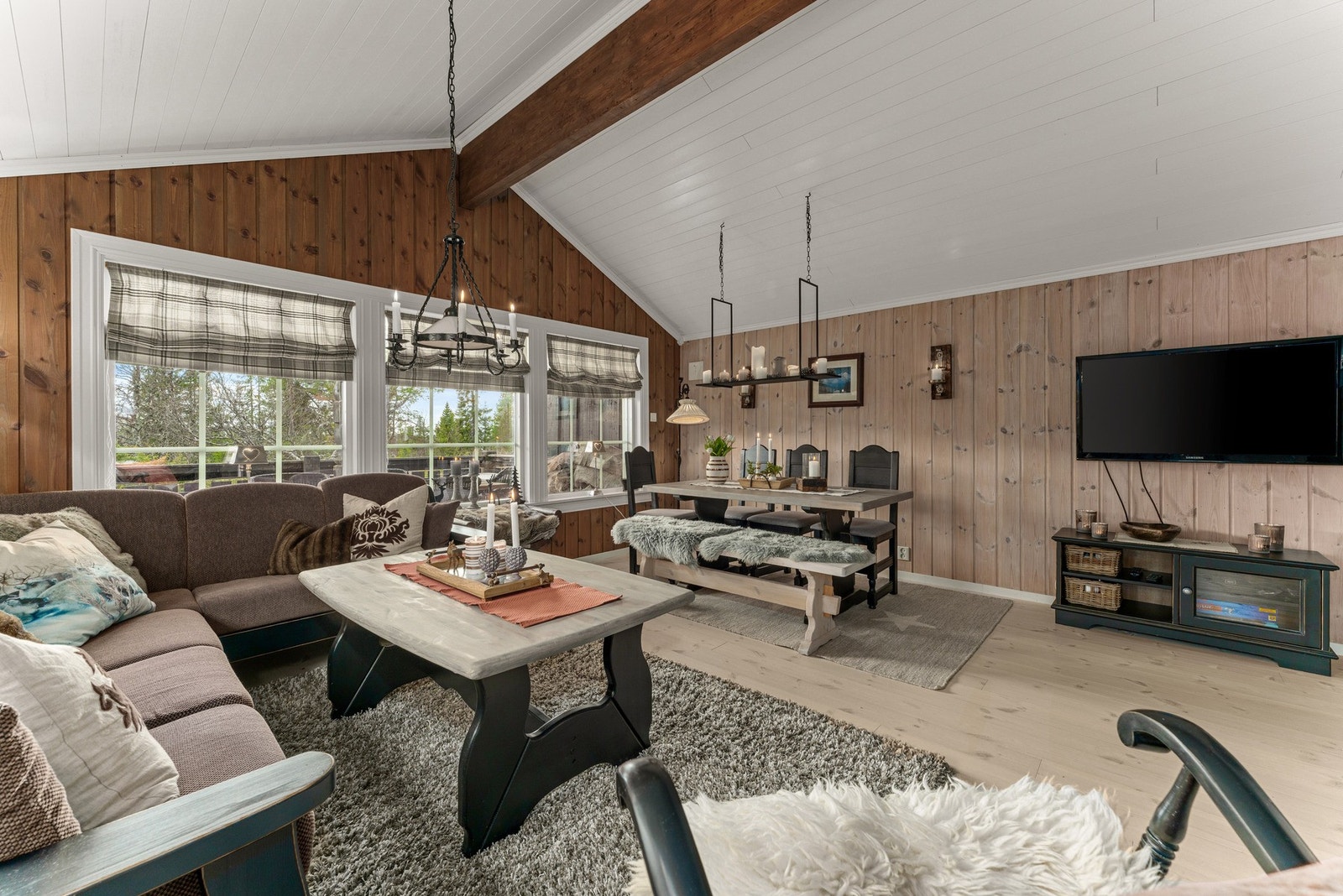 Stuen er et stemningsfullt og innbydende rom med god takhøyde og synlige bjelker. Galleribilde