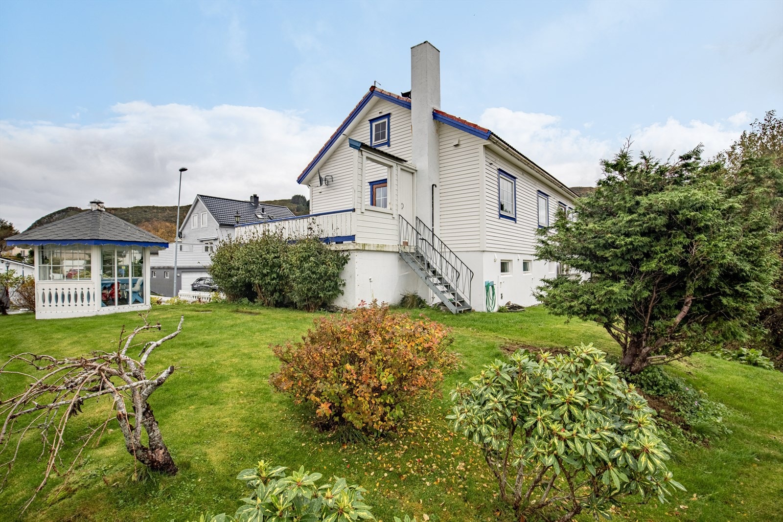 Boligen har en attraktiv beliggenhet med grillhytte og en velstelt hage som gir et innbydende uteområde Galleribilde