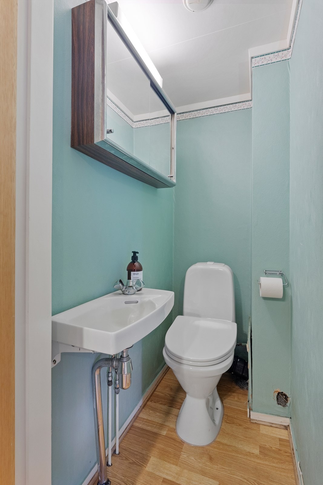 Toalettrommet i underetasjen er innredet med gulvbelegg og tapet på vegger Galleribilde