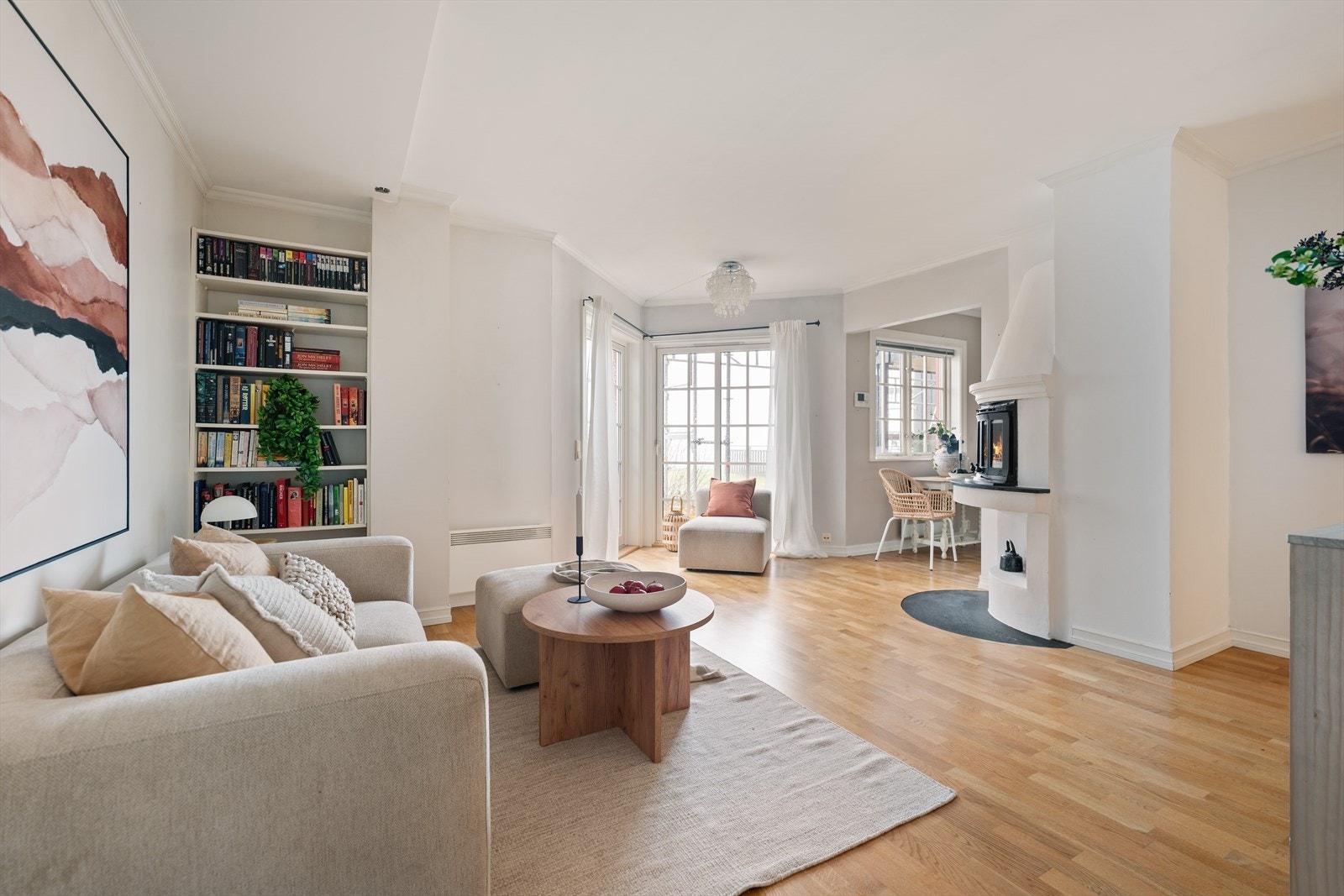 Stuen har en åpen og innbydende planløsning med peis og store sprossevinduer som slipper inn rikelig med naturlig lys. Galleribilde