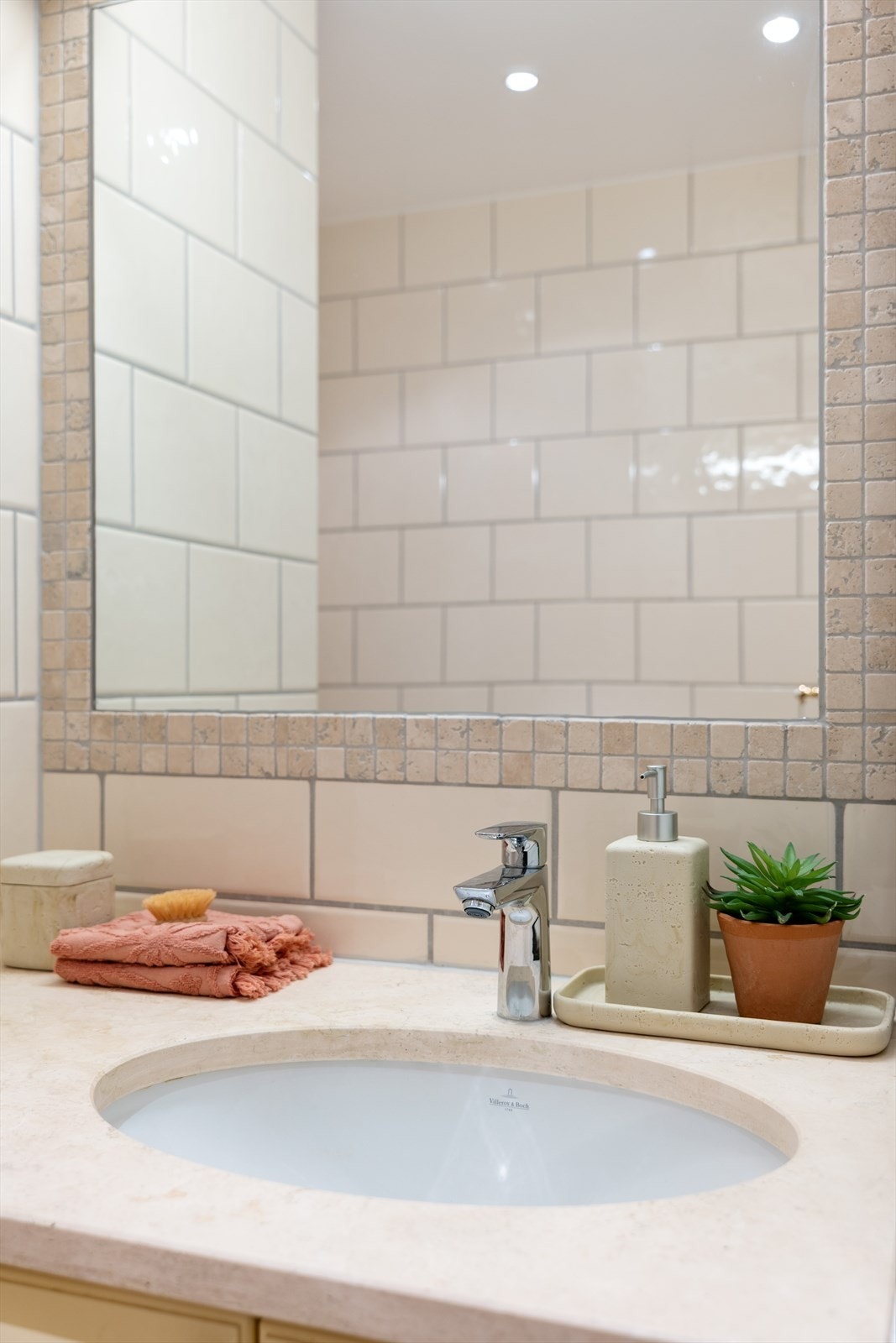 Badet har lys innredning med skapseksjon, steinplate og underlimt servant, samt innfliset speil og vegghengt toalett. Galleribilde