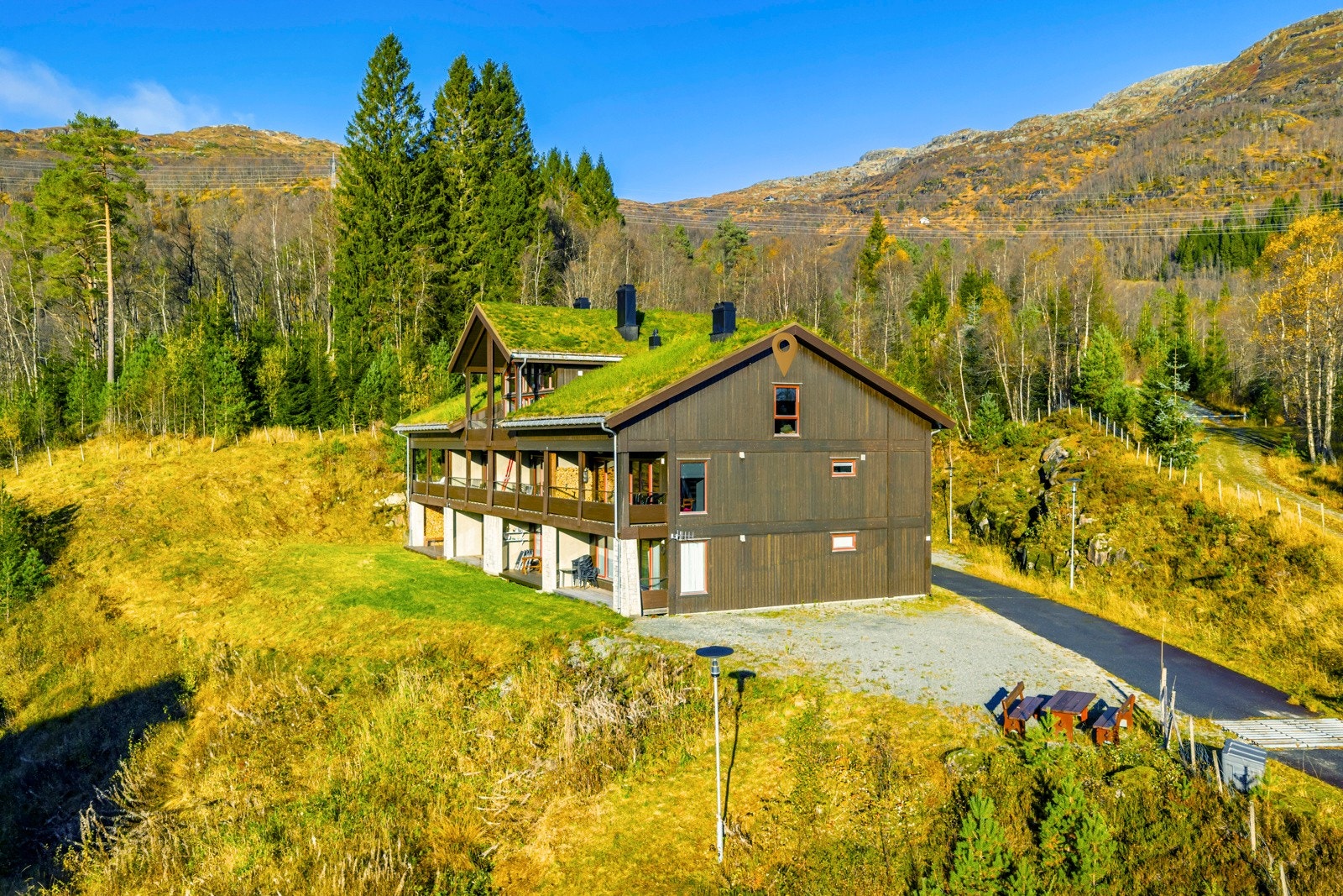 Leilighetsbygg med flere leiligheter oppført i betong og trekonstruksjoner, taket er utvendig tekket med torv. Galleribilde