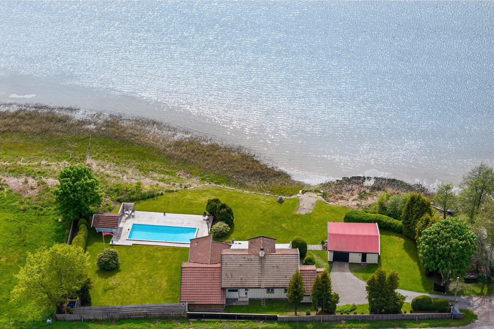 Pent opparbeidet tomt med gressplen, basseng og strandlinje Galleribilde