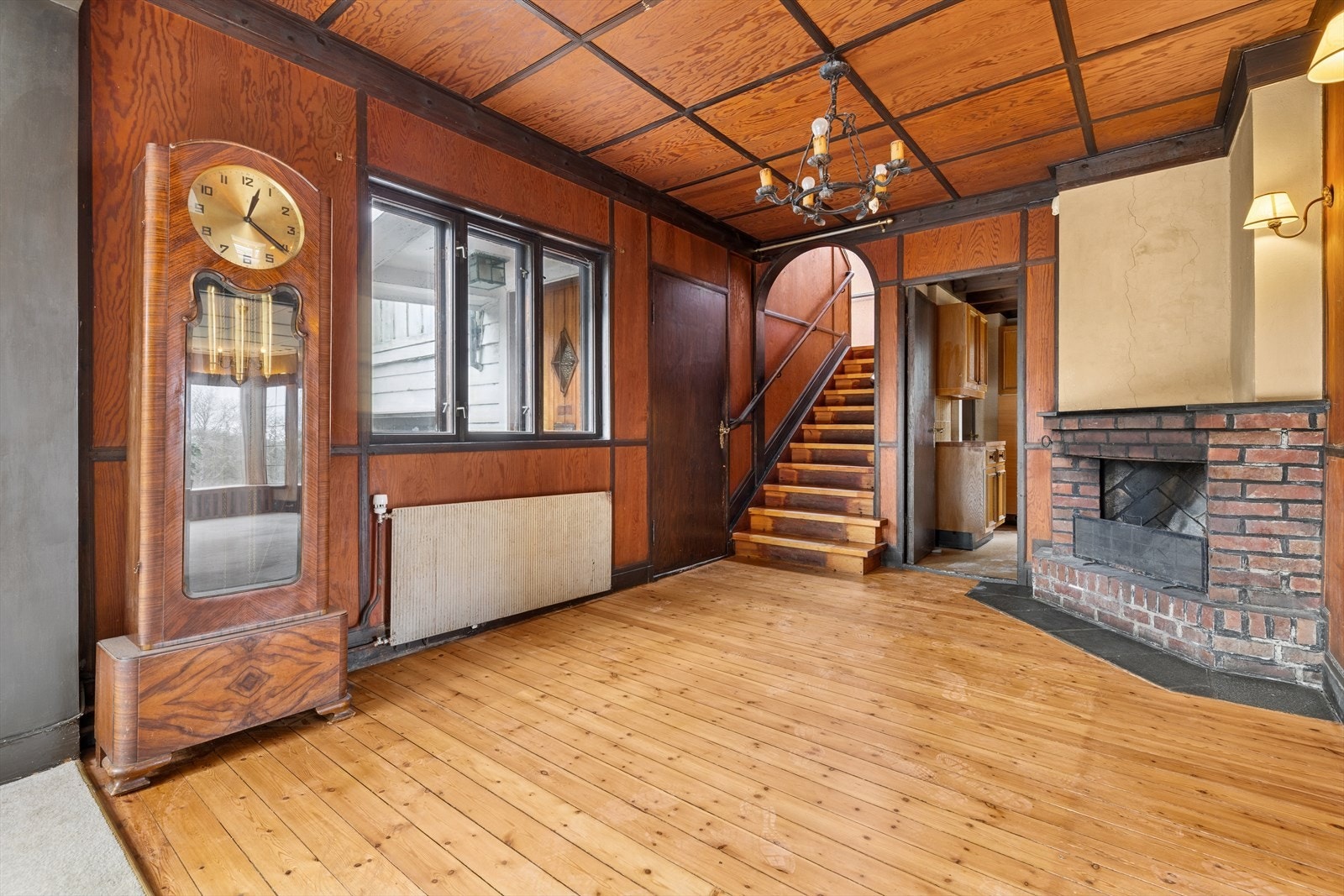 Romslig gang med klassiske overflater, flott takhøyde og vedfyrt peis som gir et varmt og innbydende preg. Galleribilde