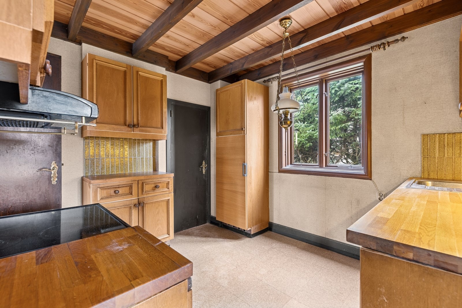 Lyst og romslig kjøkken med gode arbeidsflater, originale skapfronter og trivelig utsyn mot hagen. Galleribilde