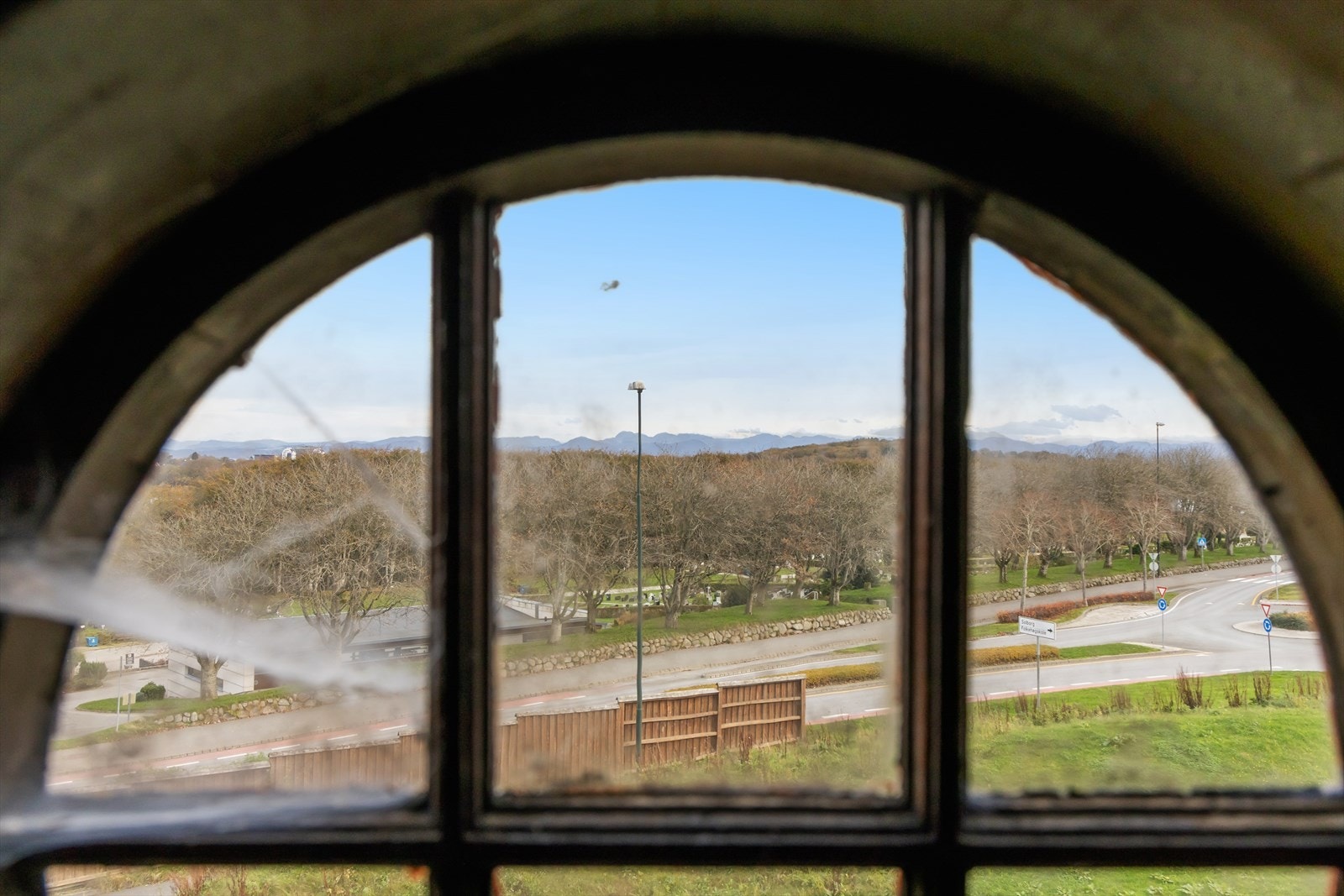 Sjarmerende loftsvindu med utsyn over nærområdet og fjellene i det fjerne - et vakkert glimt av omgivelsene som omkranser eiendommen. Galleribilde