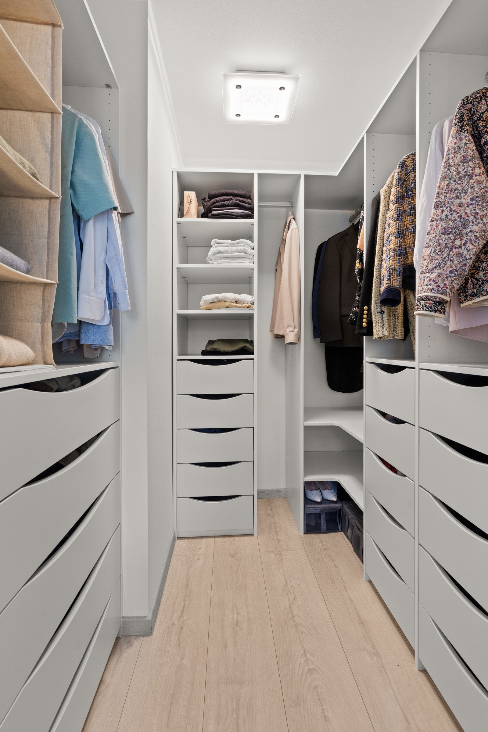 Skyvedører med speilfronter leder inn til et stilfullt walk-in closet. Garderoben byr på rikelig med oppbevaringsplass og oversiktlig innredning med klesheng, hyller og skuffer. Galleribilde