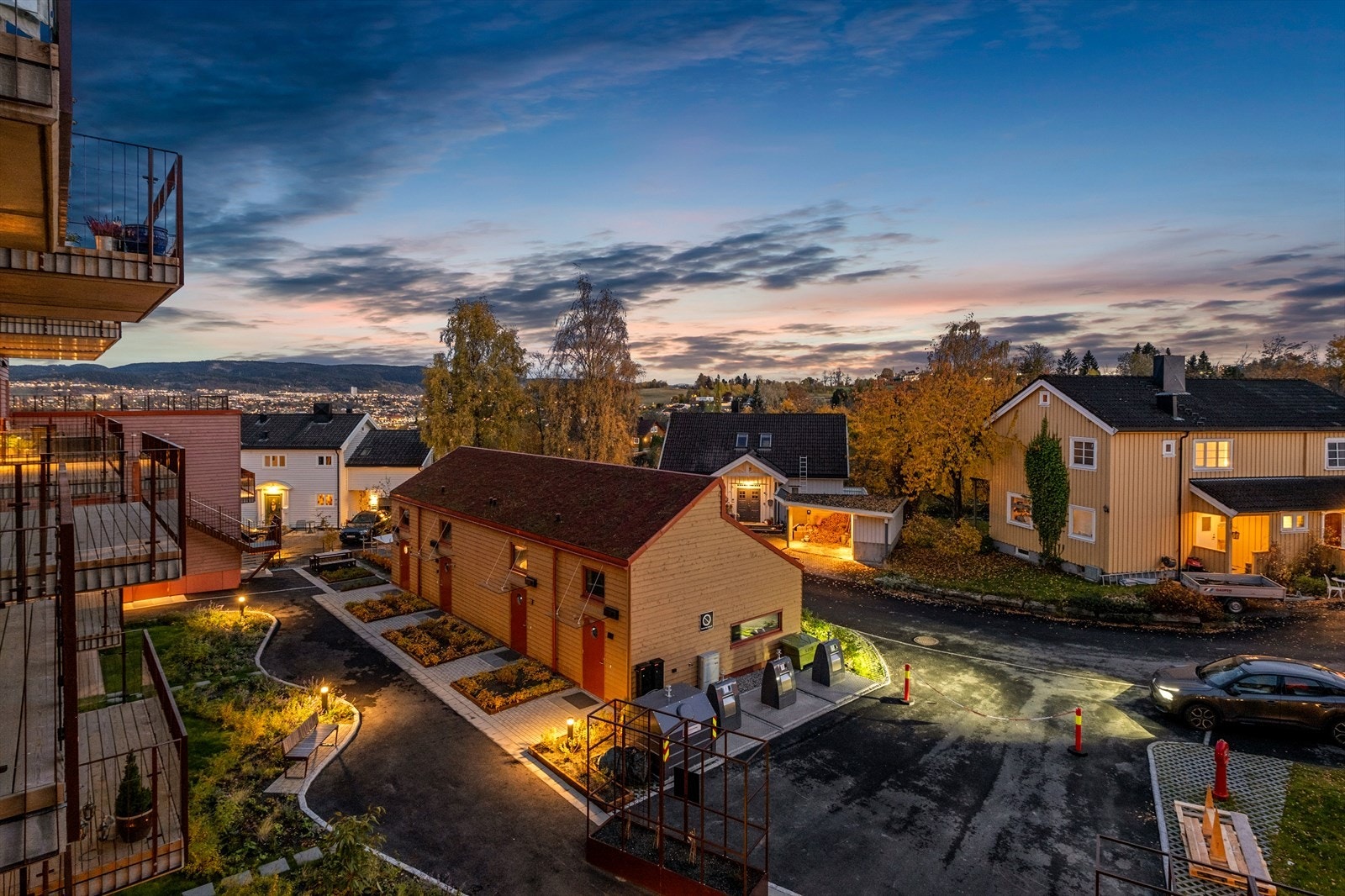 Ovenfrabildet tatt fra leilighetens balkong med utsikt over fellesområdet for sameiet. Galleribilde