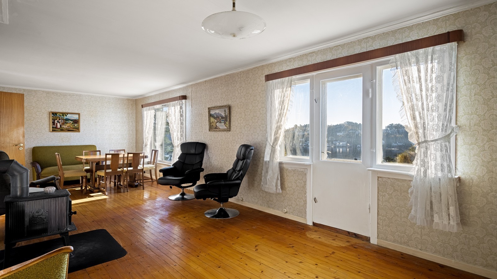 Boligen har en stue av fin størrelse med store vindusflater Galleribilde