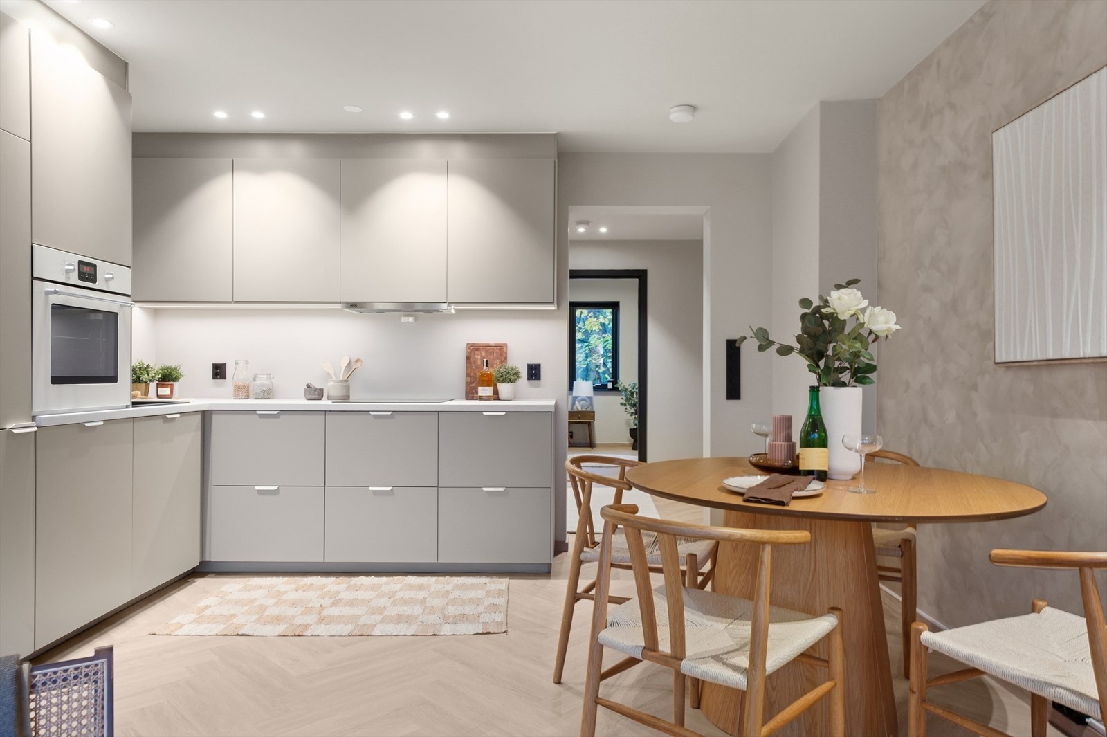 Her er det en stilfull kjøkkeninnredning fra 2025 med glatte fronter og laminat benkeplate med oppvaskkum av kompositt. Galleribilde