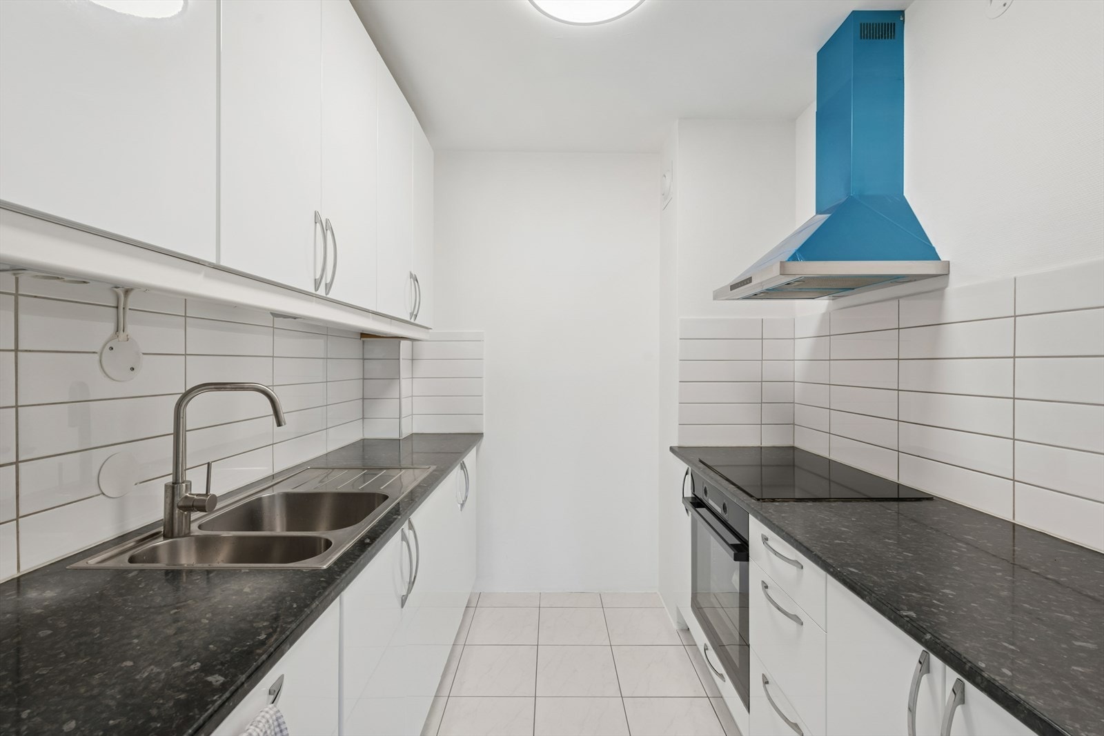 Kjøkkenet fremstår lyst, tidløst og innbydende - med hvite, glatte fronter som gir et rent og moderne uttrykk. Galleribilde