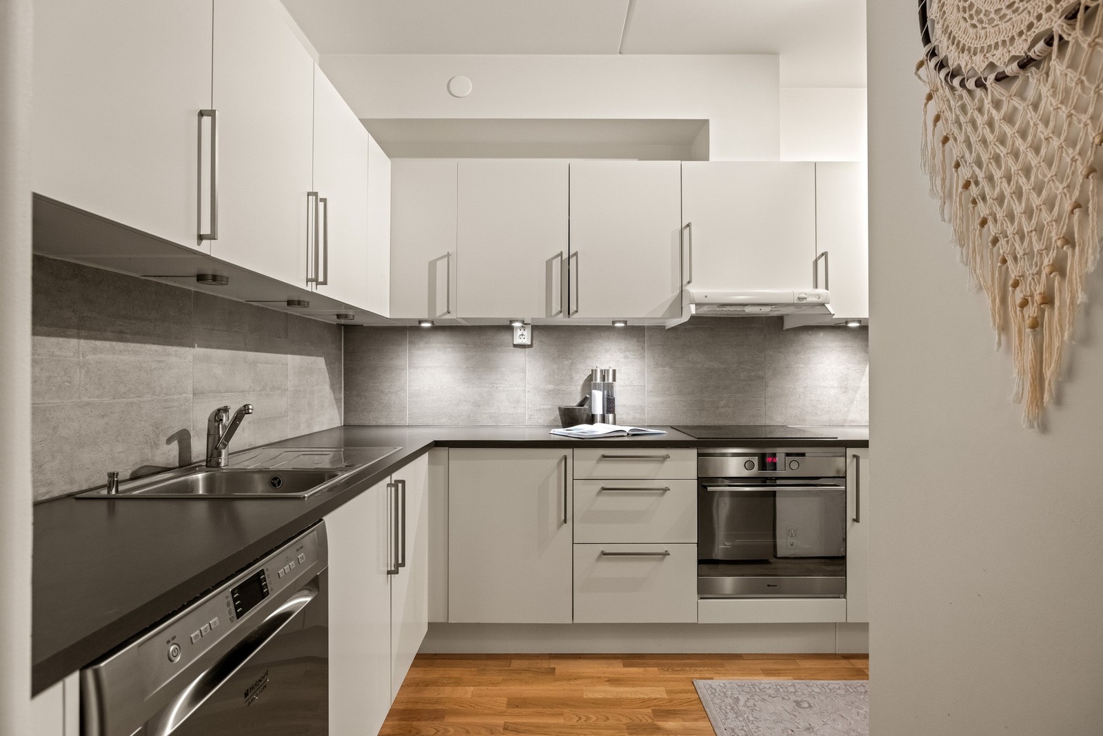 Benkeplaten i laminat og det flislagte feltet mellom benk og overskap gir en praktisk og pent helhetlig utførelse. Galleribilde