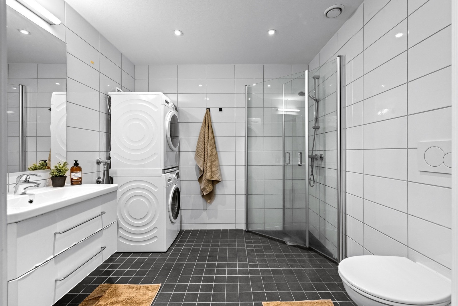 Baderommet er lekkert innredet og har en moderne, tidløs stil. Flislagt gulv og vegger gir et rent uttrykk, mens gulvvarmen sørger for en lun og behagelig start på dagen. Galleribilde