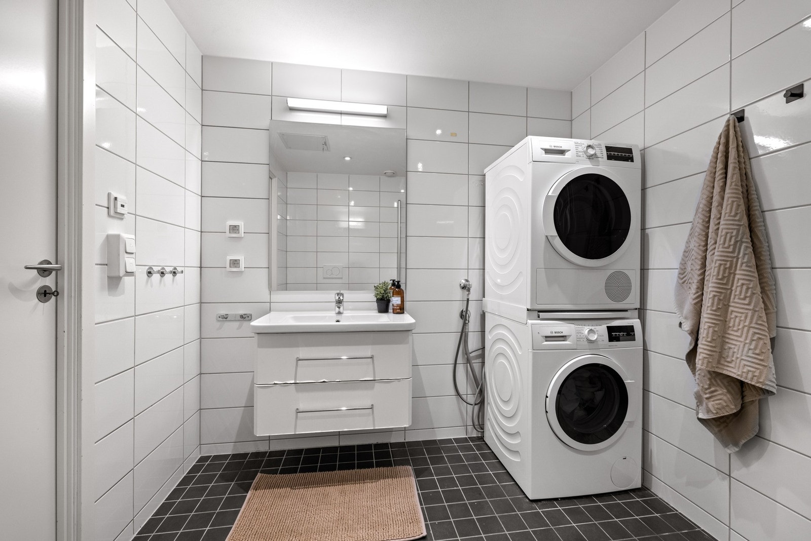 Innredningen er bestående av servantskap med skuffer, speil med lys, vegghengt toalett, dusjhjørne med innfellbare dører og opplegg for vaskemaskin/tørketrommel. Galleribilde