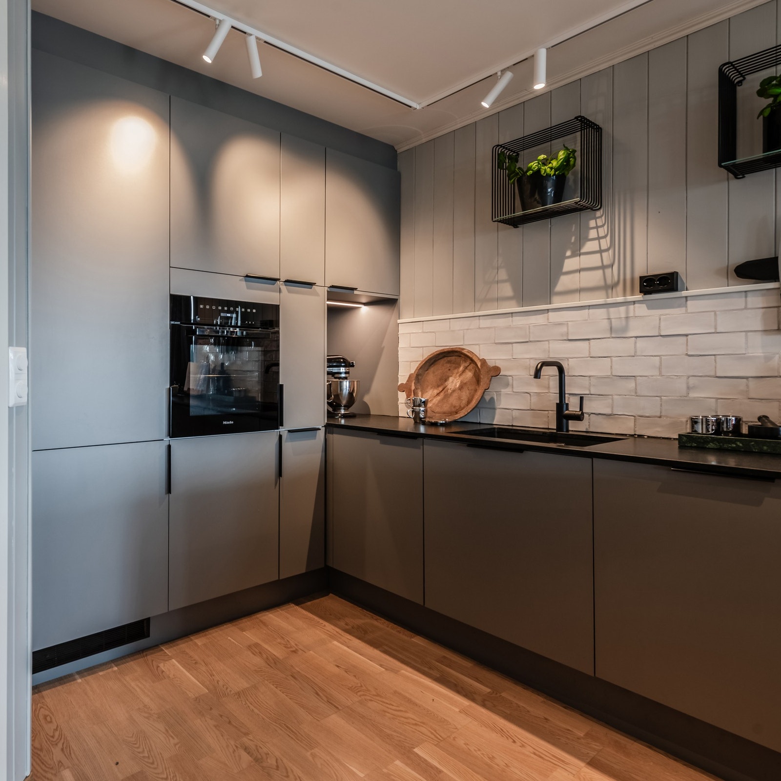 Benkeplaten i stein fra NERO Stein og fliser over benk gjør kjøkkenet både funksjonelt og enkelt å vedlikeholde. Galleribilde