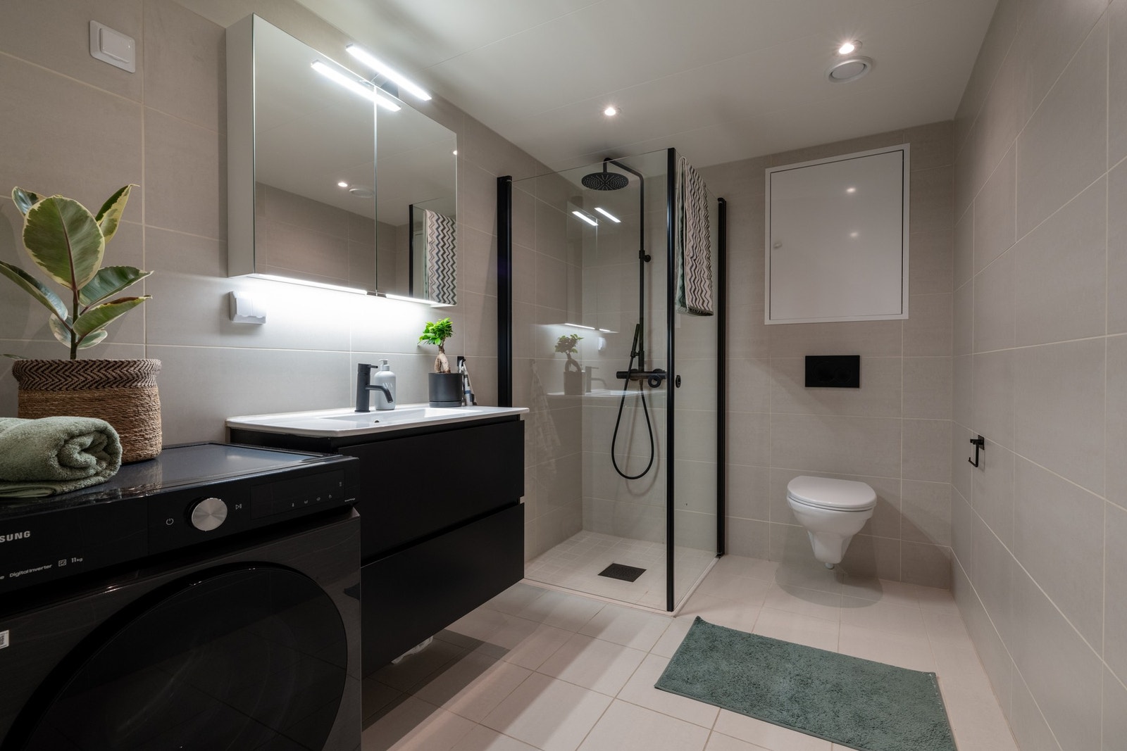 Det største badet er utstyrt med baderomsinnredning med skuffer og servant, dusj med regnfalldusj og innadslående dusjvegger, samt vegghengt toalett. Galleribilde