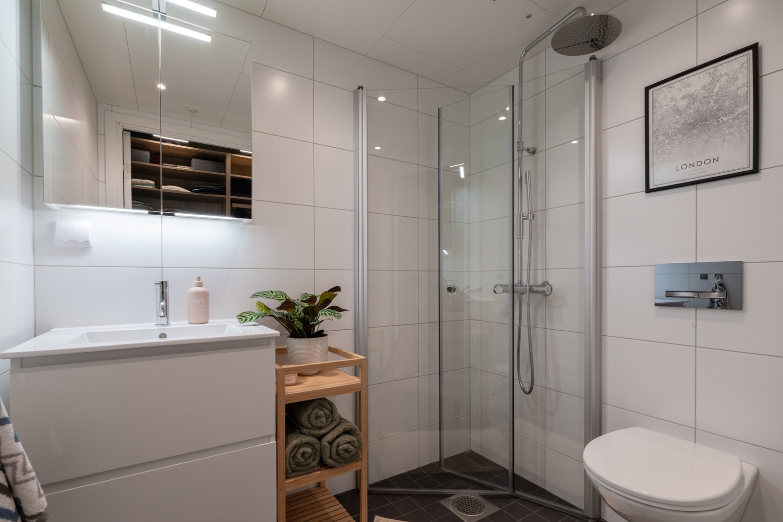 Badet er utstyrt med baderomsinnredning med skuffer og servant, speilskap, dusj med innadslående dusjvegger, samt vegghengt toalett. Galleribilde