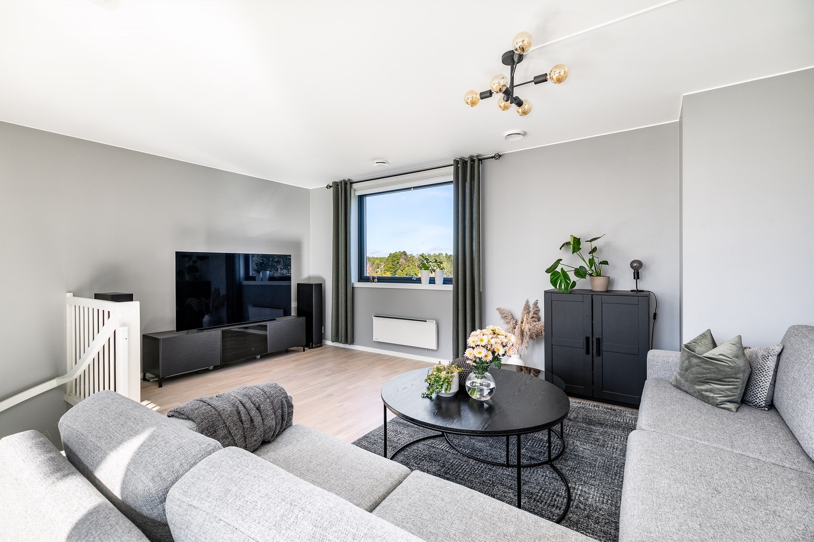 Vinduer på tre sider gir gjennomgående dagslys i stuen på øvre plan. Galleribilde