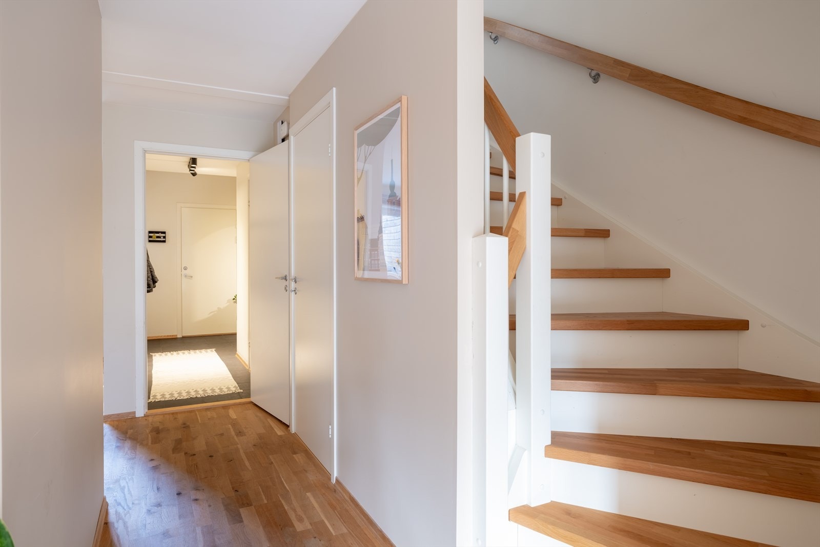 Trapp med hvitmalt rekkverk og parkett, varmtvannsbereder på 200 L fra 2014 under trappen. Galleribilde