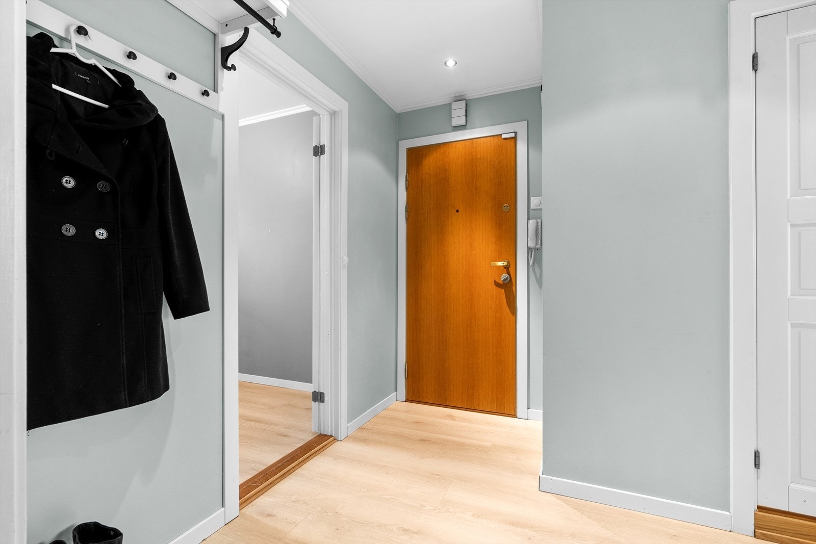 Leiligheten har en innbydende entré med downlights i himlingen. Elektronisk dørlås fra 2021 gir deg nøkkelfri adgang. Lås og lås opp enkelt og sikkert med Unlock-appen, superpraktisk ved gjester, levering og hverdagsbruk. Galleribilde