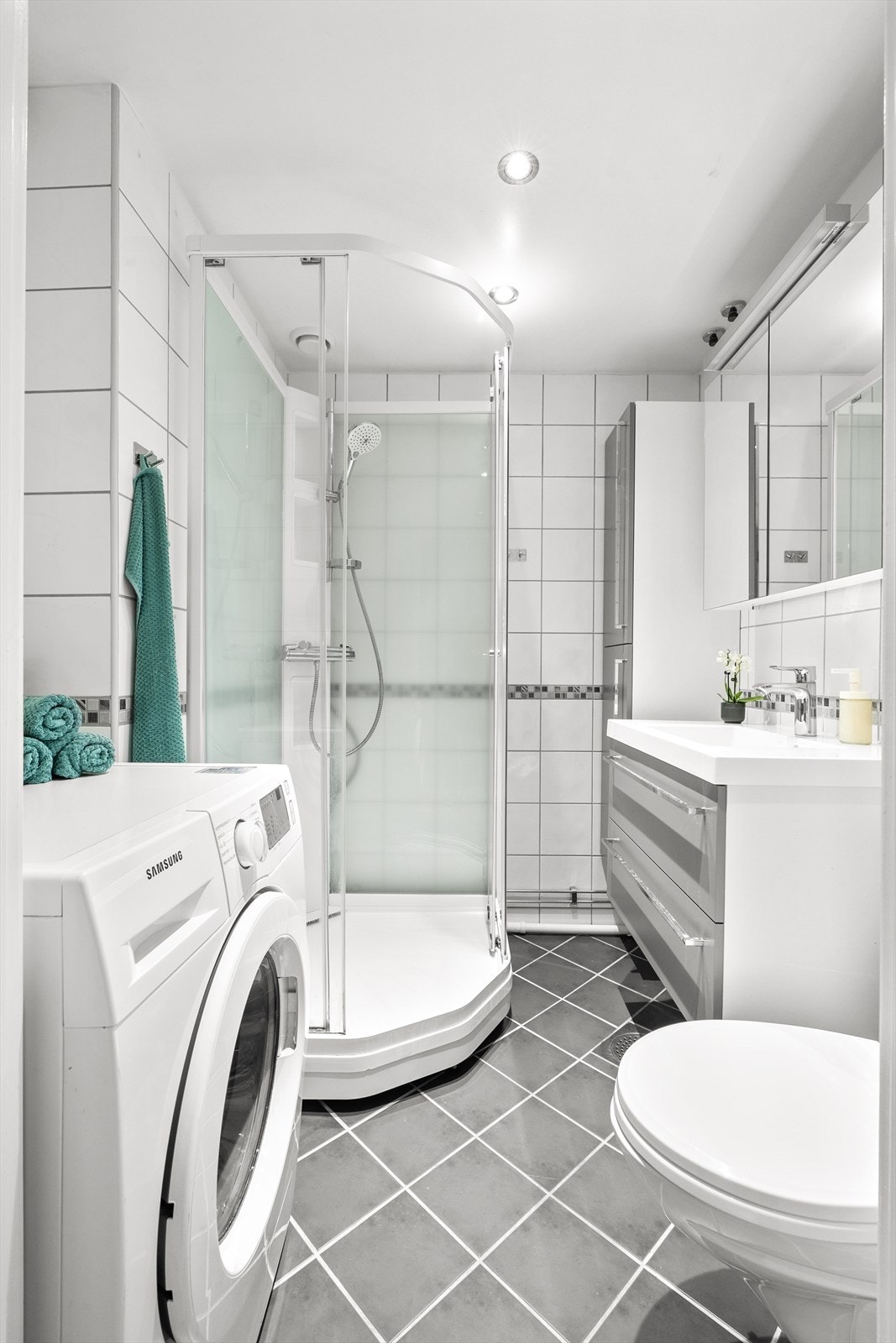 La oss også ta en titt på baderommet. Baderommet ble pusset opp i regi av borettslaget i 2006 og fremstår som lyst og pent. Badet har bl.a downlights i himlingen og elektrisk gulvvarme. Galleribilde