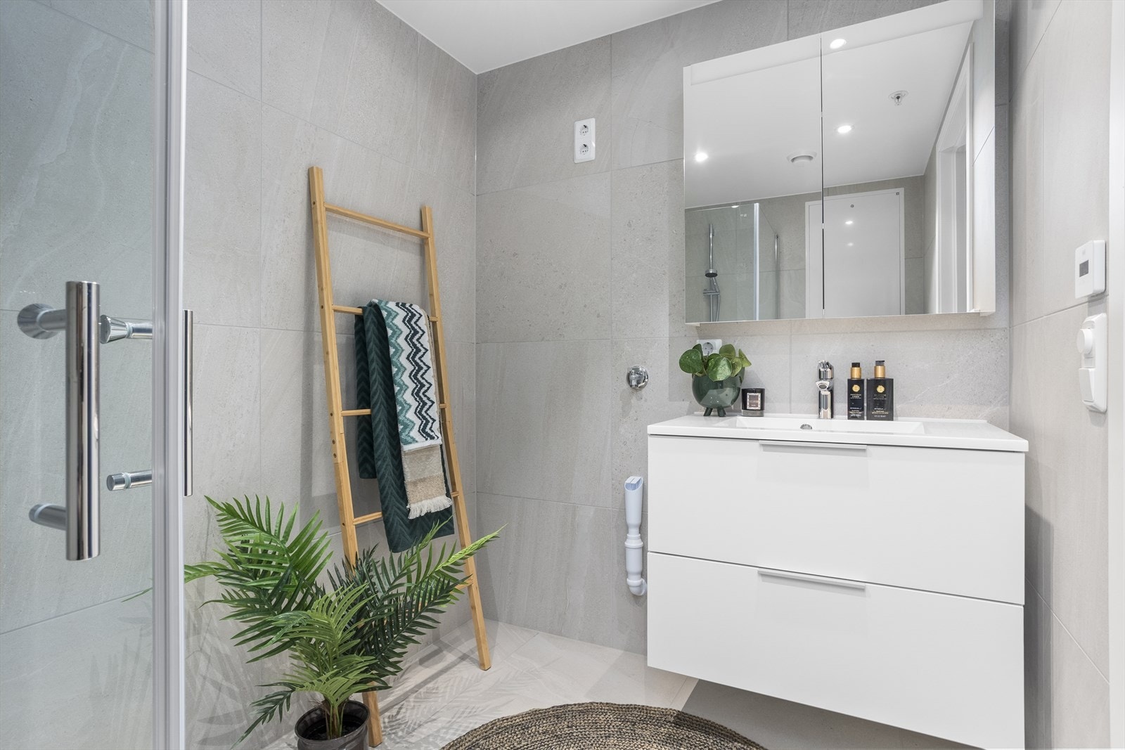 Delikat og flislagt bad på 4,4 m² med ferdig opplegg for vaskemaskin, flott baderomsinnredning og behagelig gulvvarme. Galleribilde