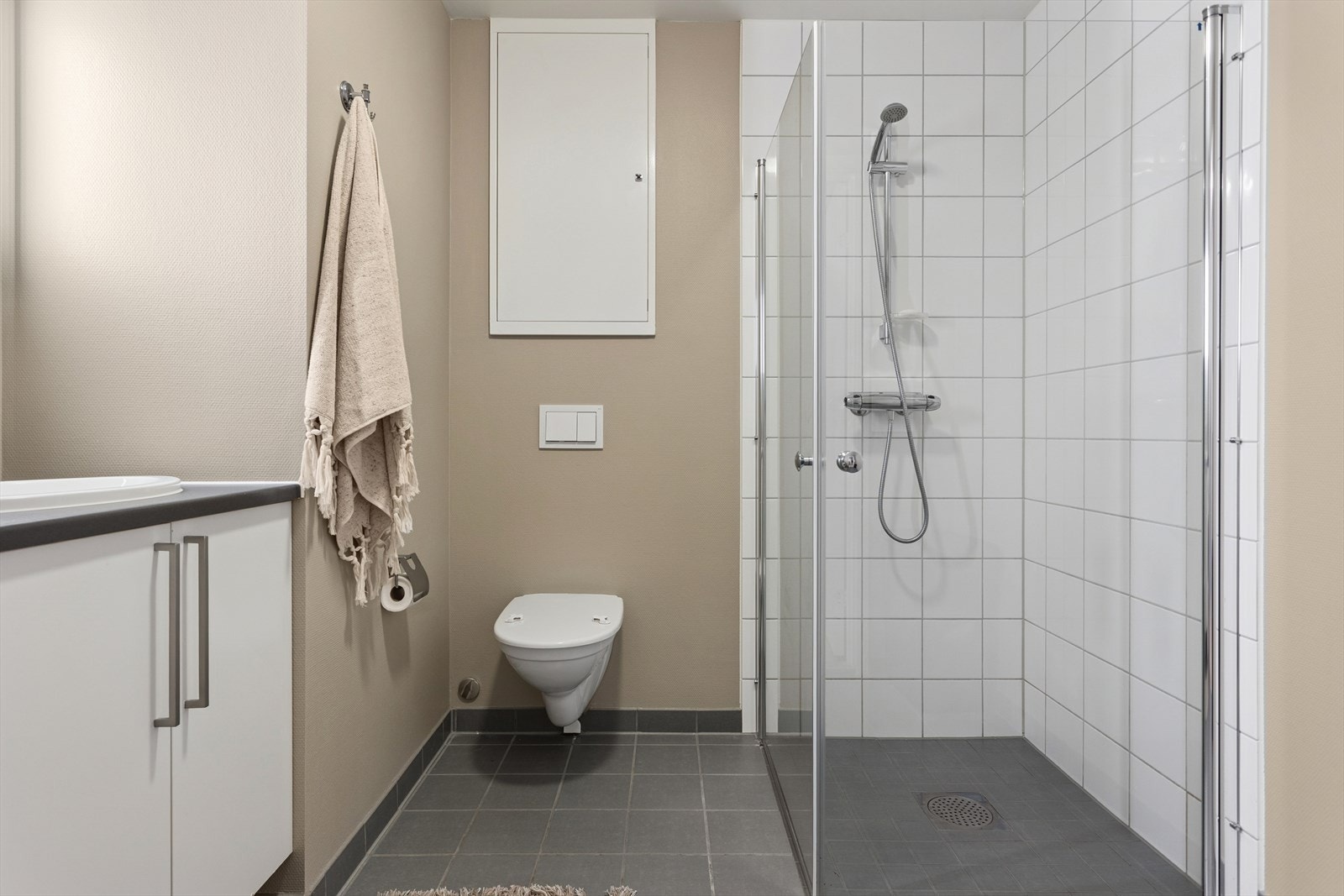 Innredningen består av speil med belysning, servant med benkeskap, veggmontert toalett, dusjhjørne og opplegg for vaskemaskin med stoppekran. Galleribilde