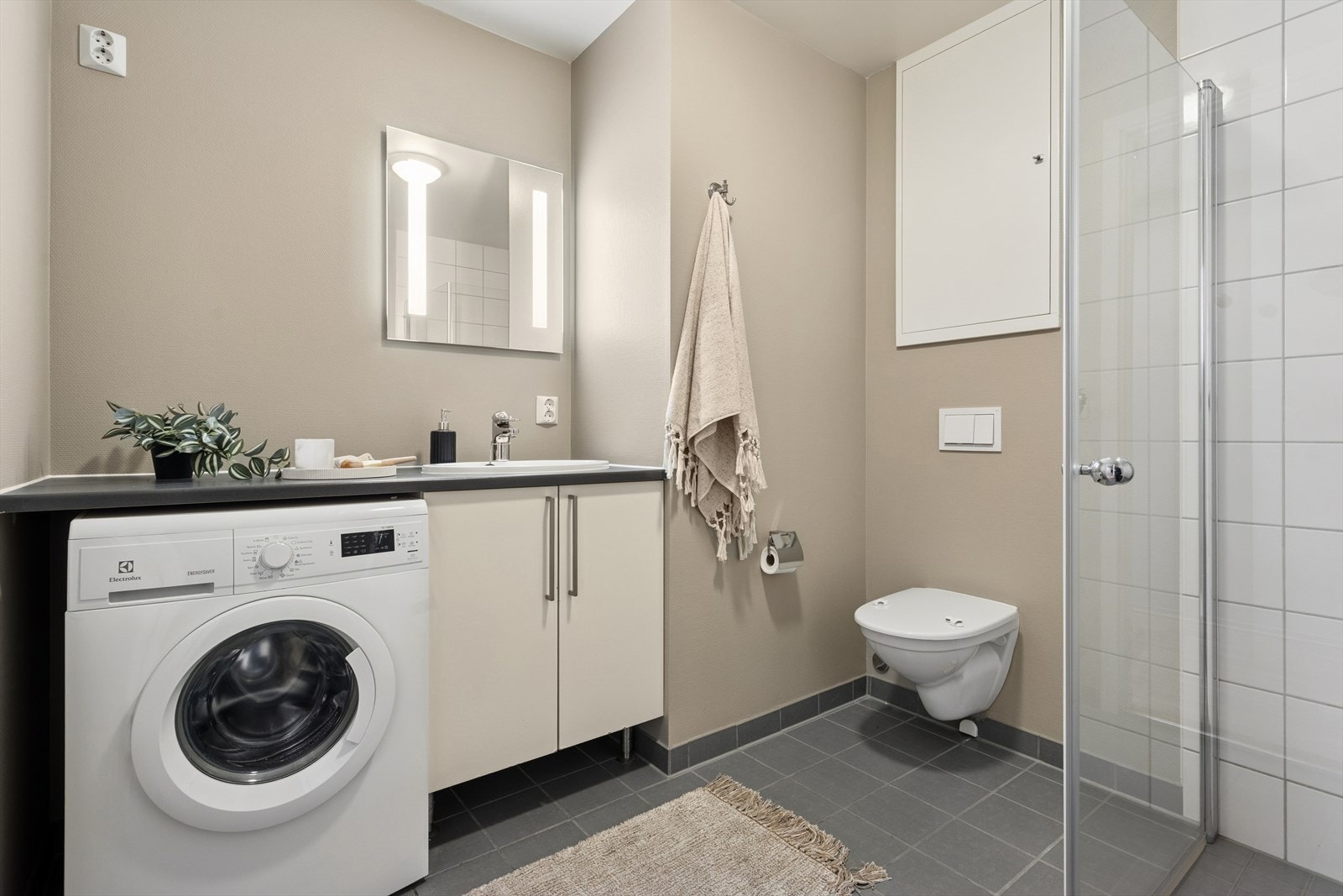 Bad/vaskerom har flislagt gulv med vannbåren varme og fliser på vegg i dusjområdet. Galleribilde