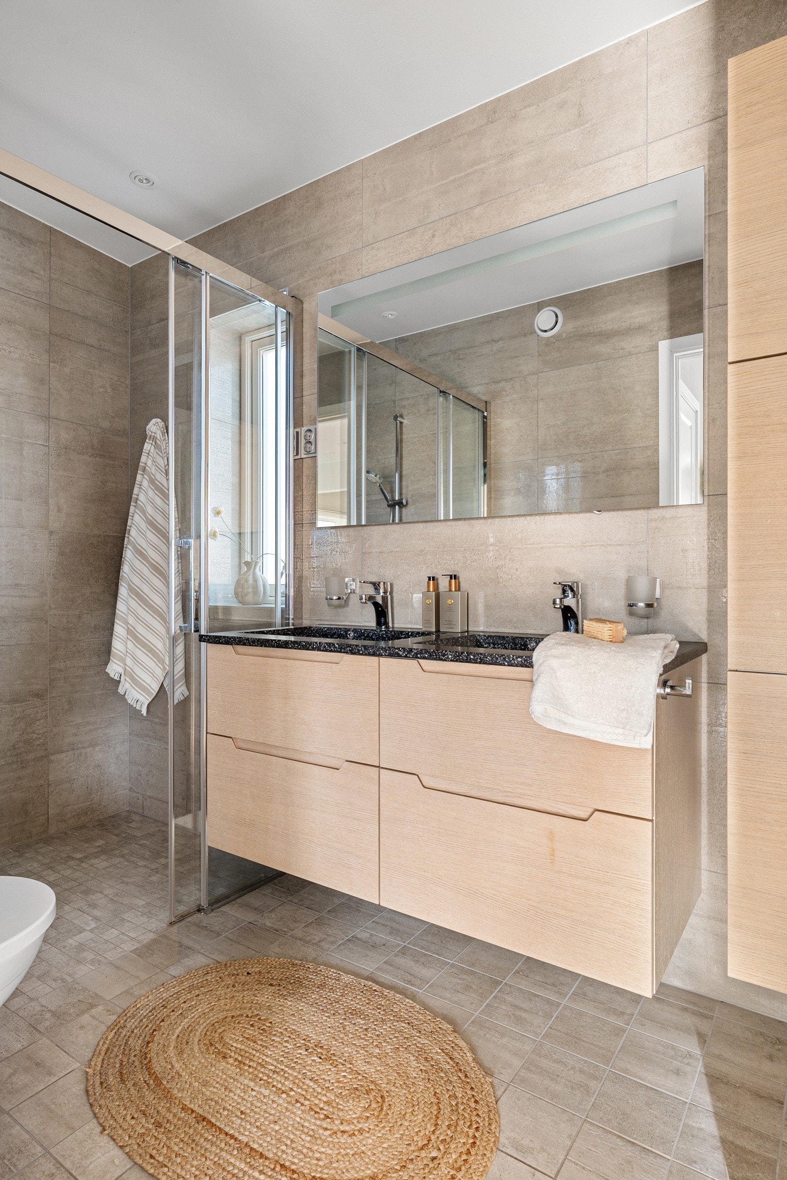 Hovedbadet har dusjhjørne med glassvegg/-dør